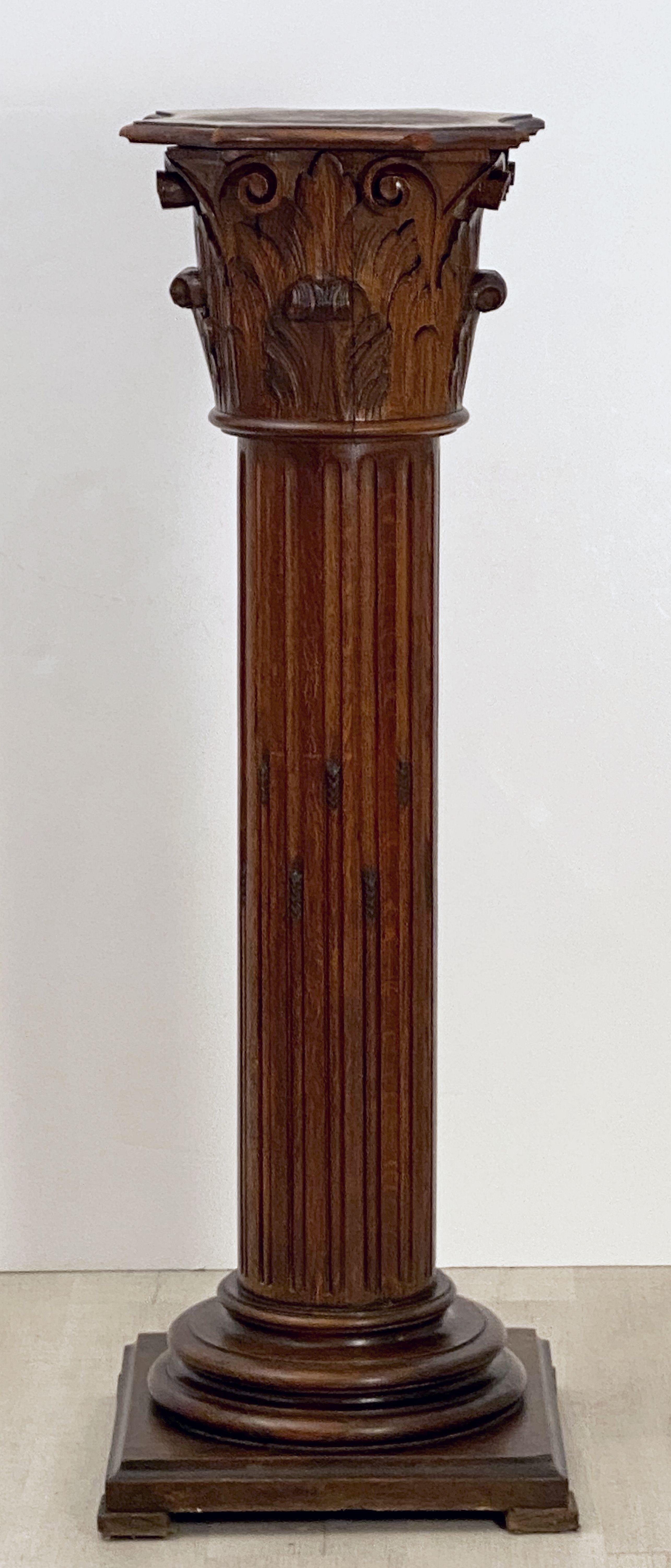 A tall finely patinated French column pedestal stand or plinth in the neoclassical style of carved wood.