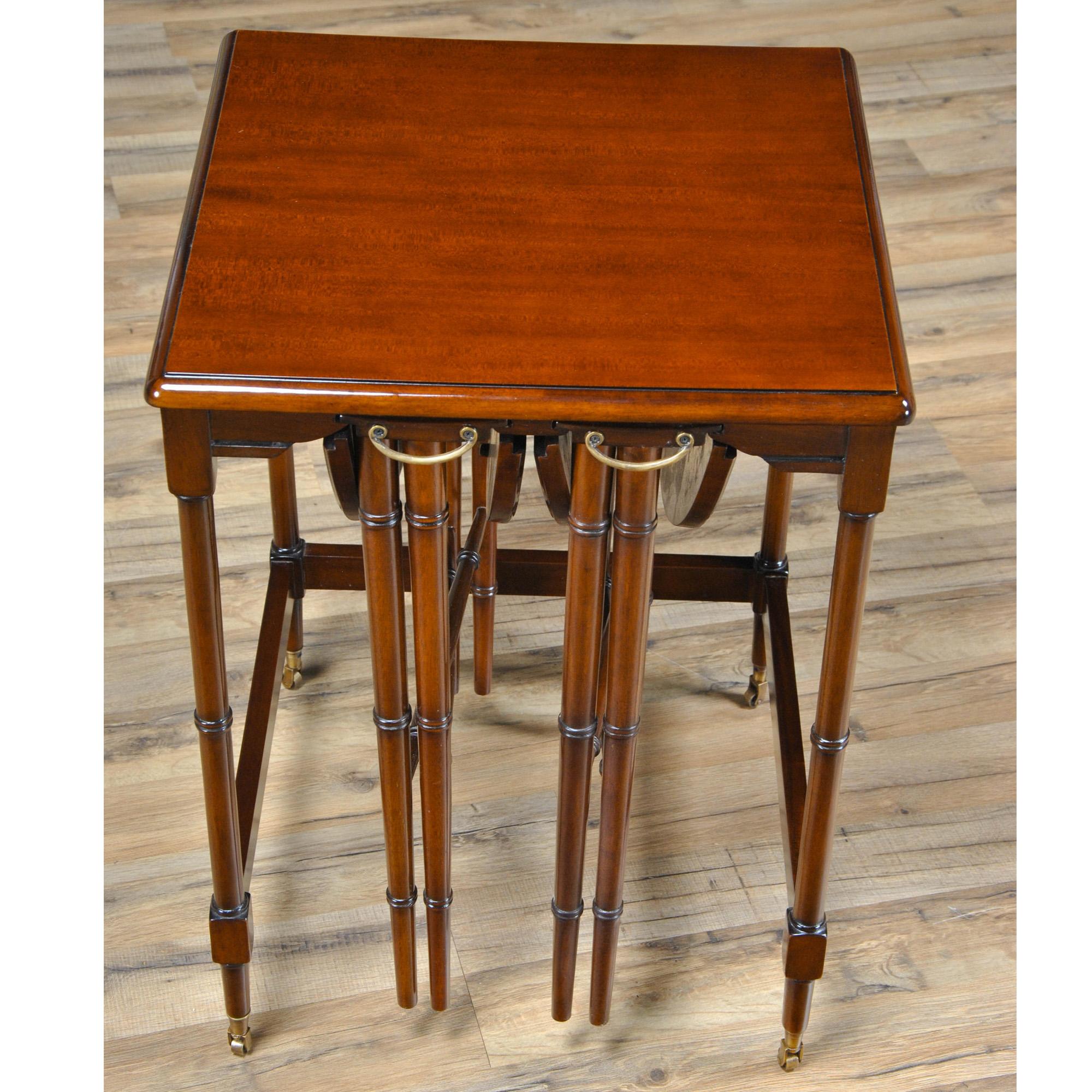 An ingenious set of three Tall Nesting Tables that stores the two smaller end tables underneath the largest table. The smaller tables unfold and open up and can be used on sturdy, solid mahogany legs which are fashioned in a faux bamboo pattern.