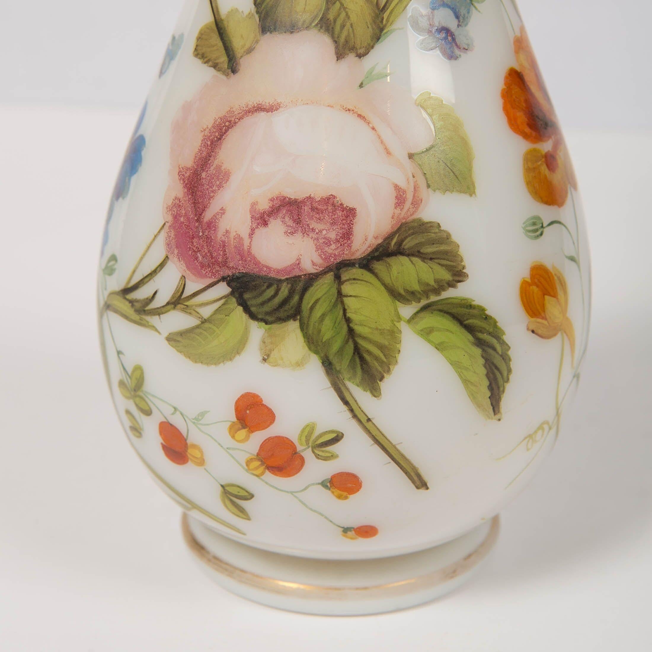 We are pleased to offer this opaline vase with beautiful hand painted flowers. 
The glass is hand blown, without seams, and is slightly translucent. 
The vase is decorated all around with beautiful roses, morning glory, lilies, and other flowers on