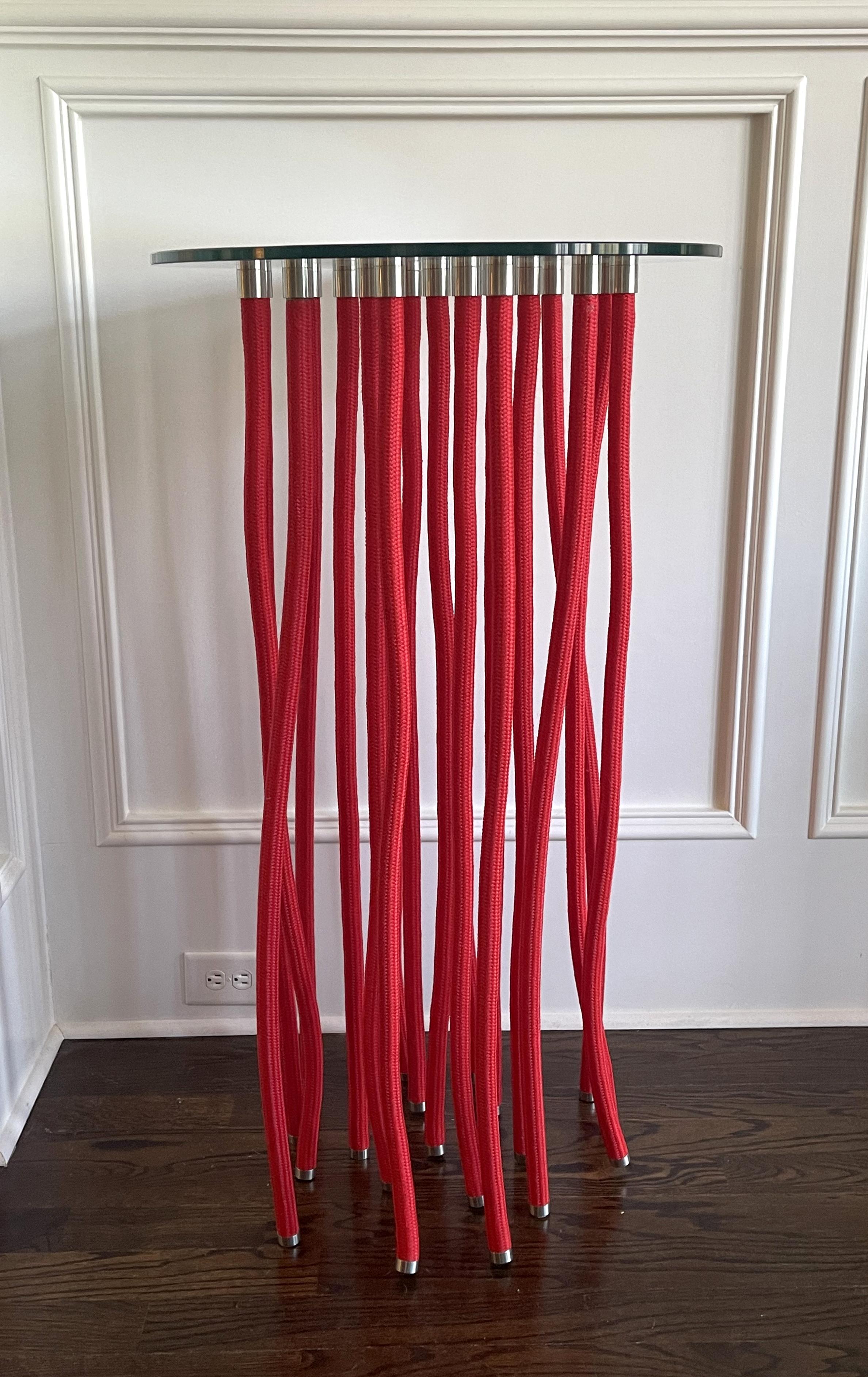 A tall red ORG table designed by Fabio Novembre (Italian, born 1967) in 2001 for Cappellini. Made of glass top supported by polypropylene rope-covered steel with exposed stainless-steel fitting. The table appears floating on the air due to the