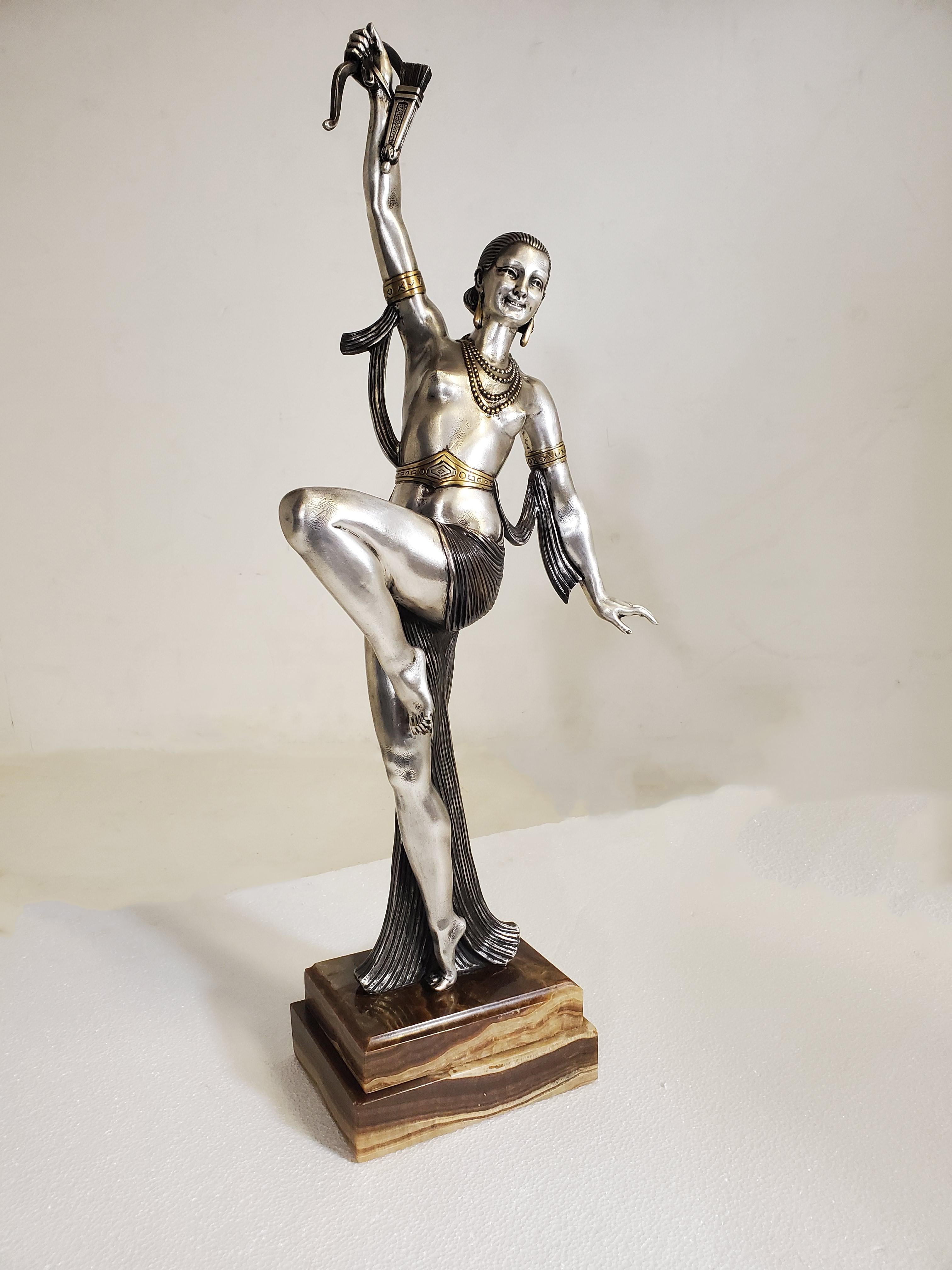 A tall original French Art Deco bronze sculpture of a semi-nude, female dancer holding a bow with arrow. 
 The striped cloth which drapes dramatically around the woman's body creates an interesting dialogue and complement to the graceful position of