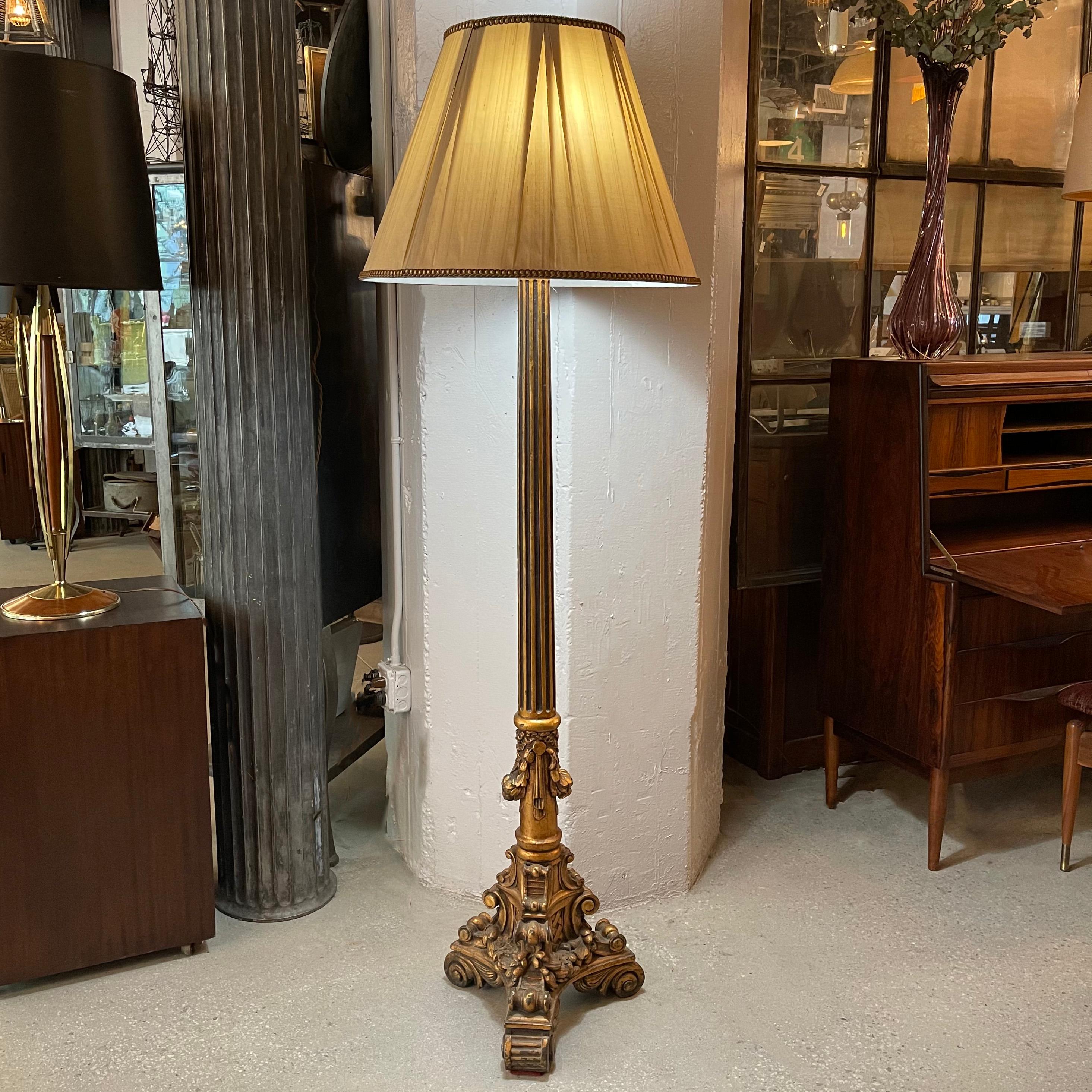 Tall, ornate, intricately carved, gilt, composite floor lamp with fluted stem in the Baroque style with vintage, pinch pleat, fabric shade.