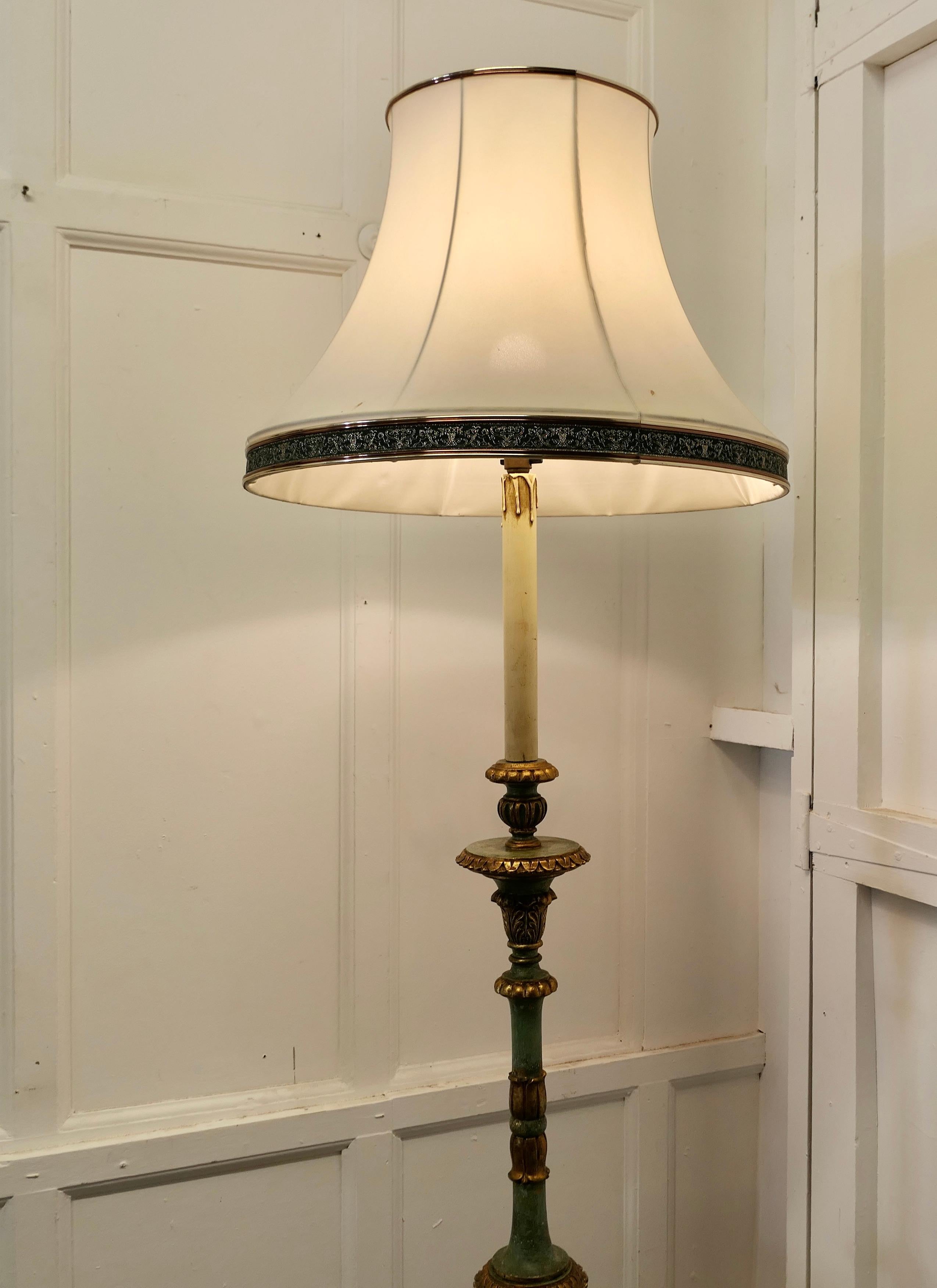 Tall painted green and giltwood floor standing or standard lamp

This is a very attractive piece in age darkened colours of moss green and gold, the lamp stands on a decorative turned and carved wooden base and column, the wiring seems to be new