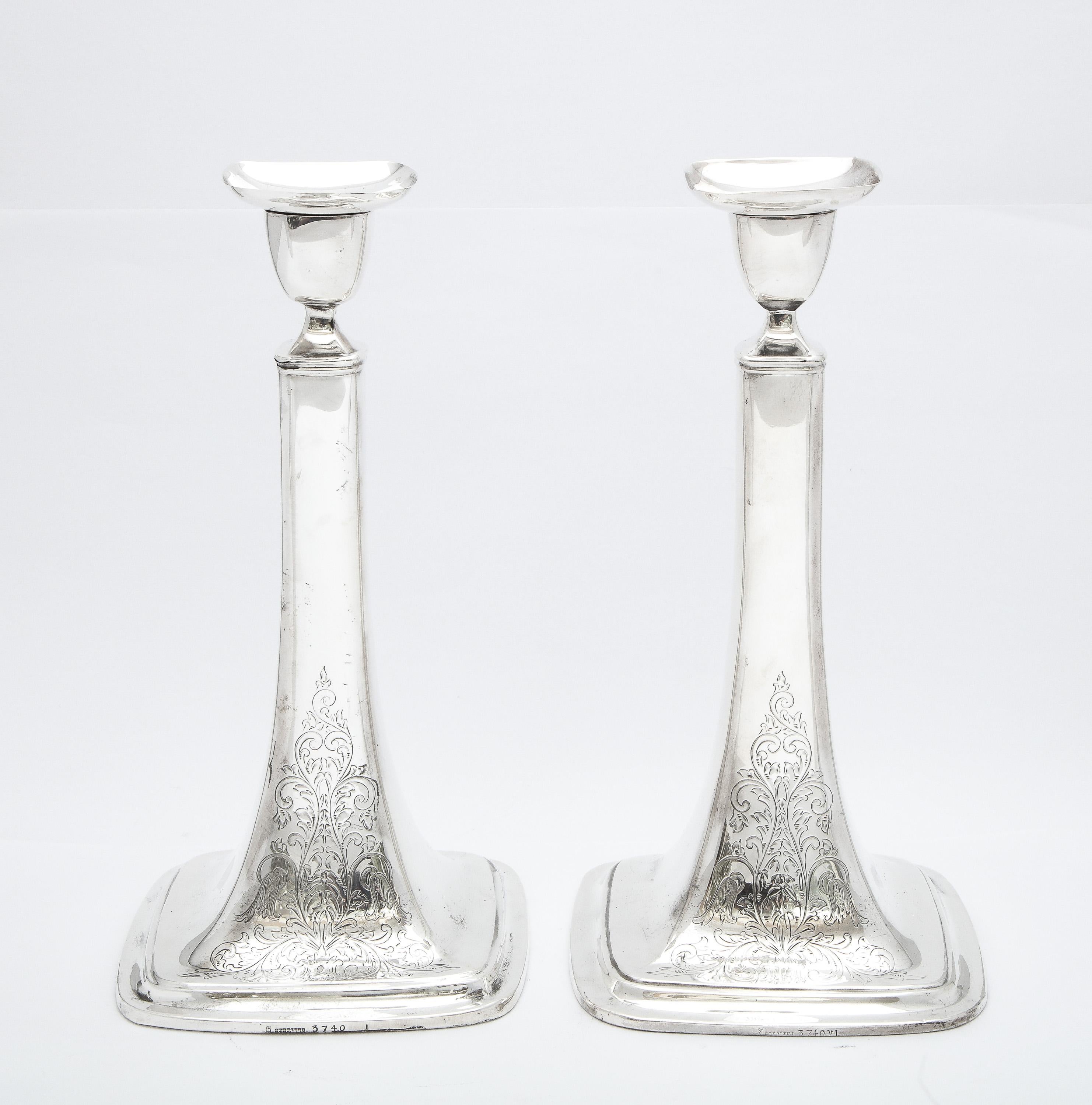 Unusual, tall pair of Edwardian Period, sterling silver candlesticks, Towle Silversmiths, Newburyport, Mass., Ca. 1915. Each candlestick measures 10 1/4 inches high x 5 1/4 inches wide x 5 1/4  inches deep at square base. One side of the gracefully