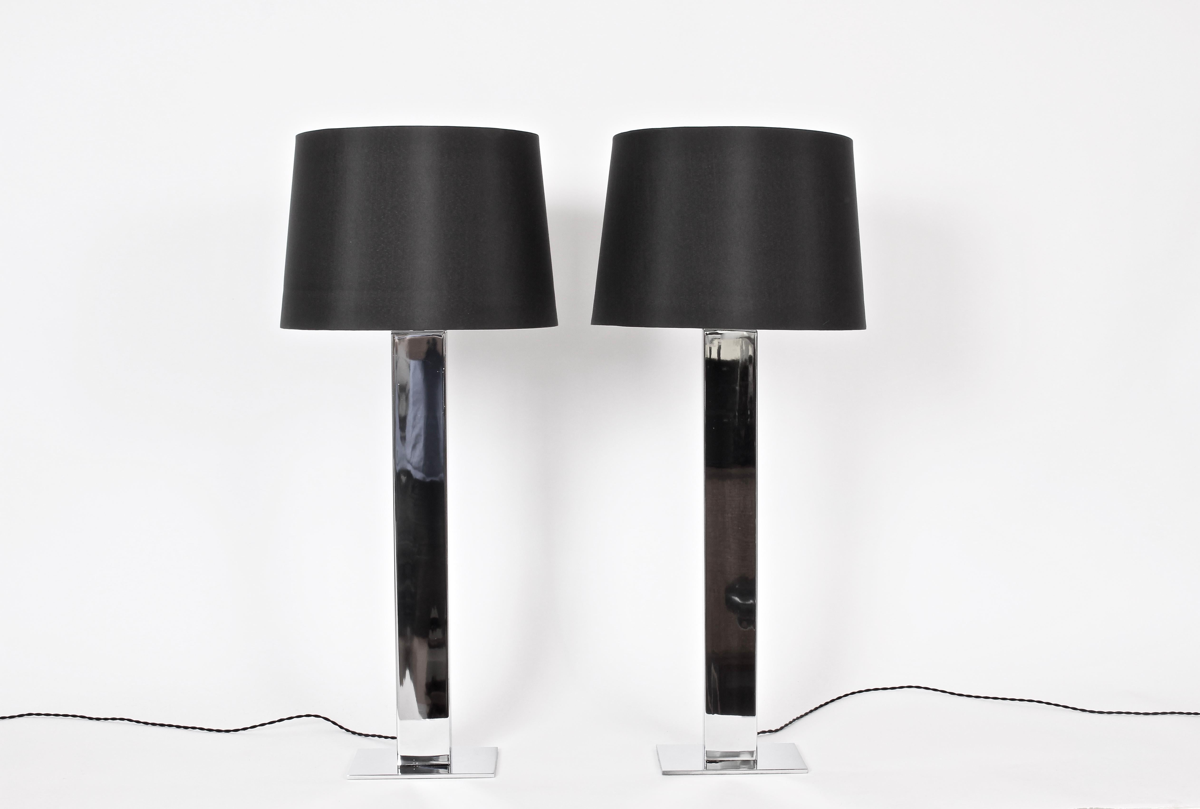 Substantial pair of reflective Chrome Plated Steel George Kovacs Table Lamps.  Featuring a slim, three foot, rectangular and heavy Chrome plated steel column on rectangular base. Small footprint. 28H to top of socket. Shades shown for display only