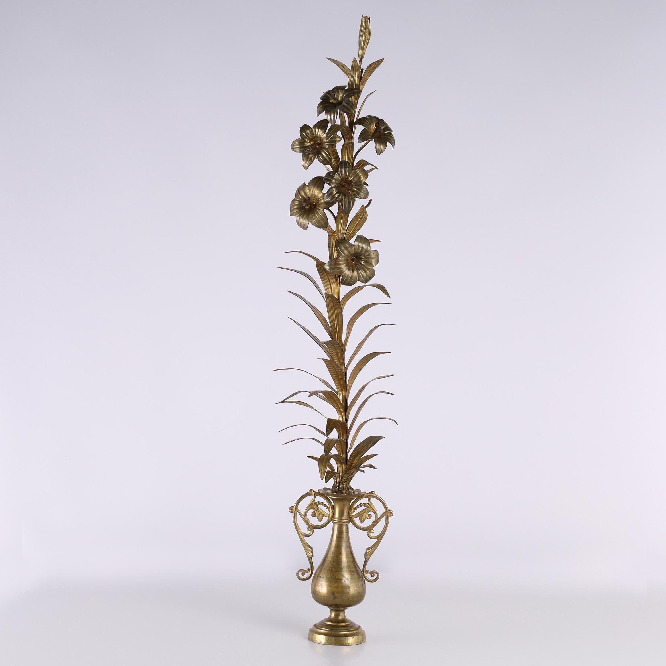 Sobresaliente par de altas guarniciones florales de latón con tallos de flores o lirios y hojas colocados en urnas de forma clásica con graciosas asas florales en forma de lazo. 