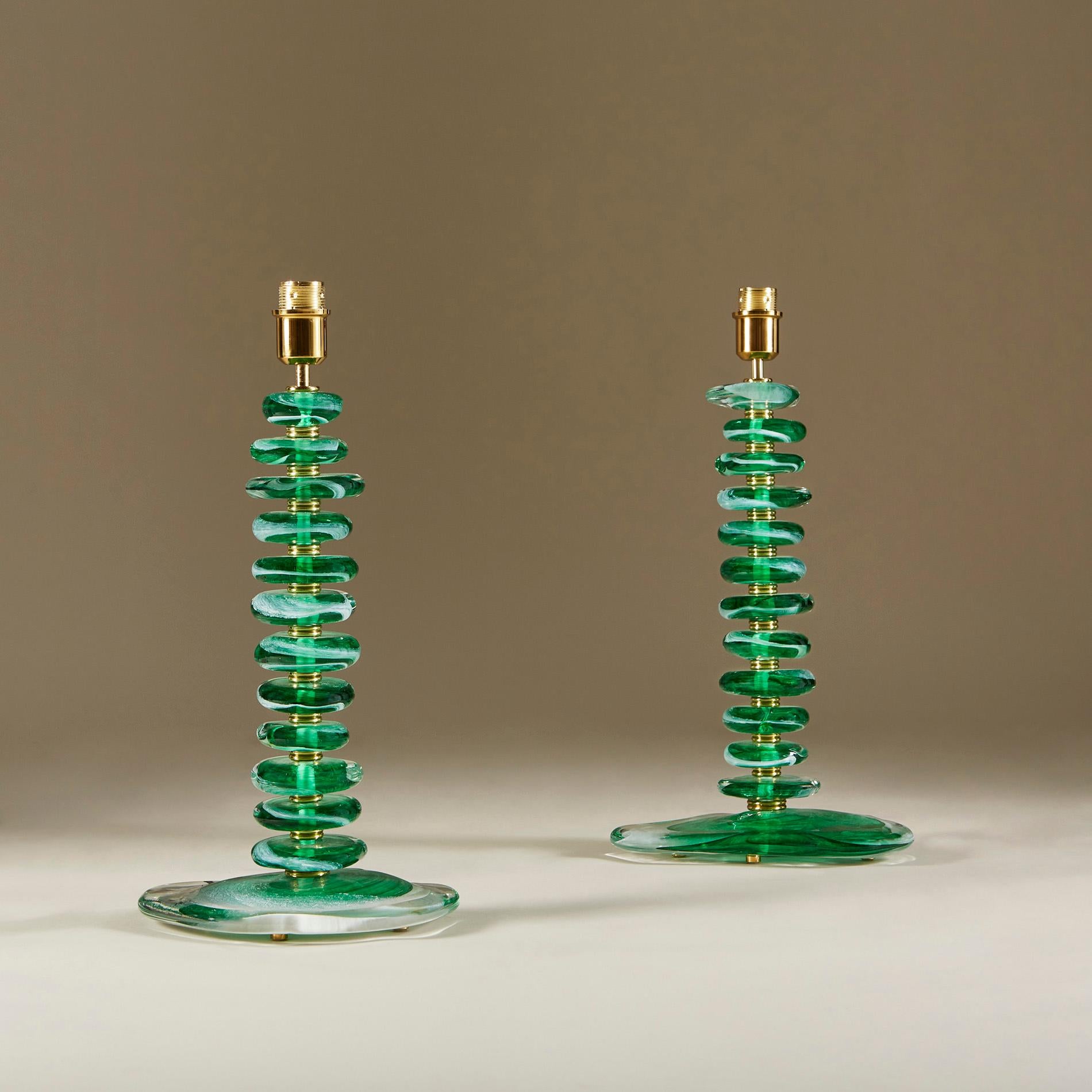 Substantial pair of contemporary table lamps. Each lamp consists of 12 handmade smooth sculptured pebbles in emerald green with clear and white detail. Each pebble is interspersed with double ribbed sections of brass and a brass lamp fitting. Sits