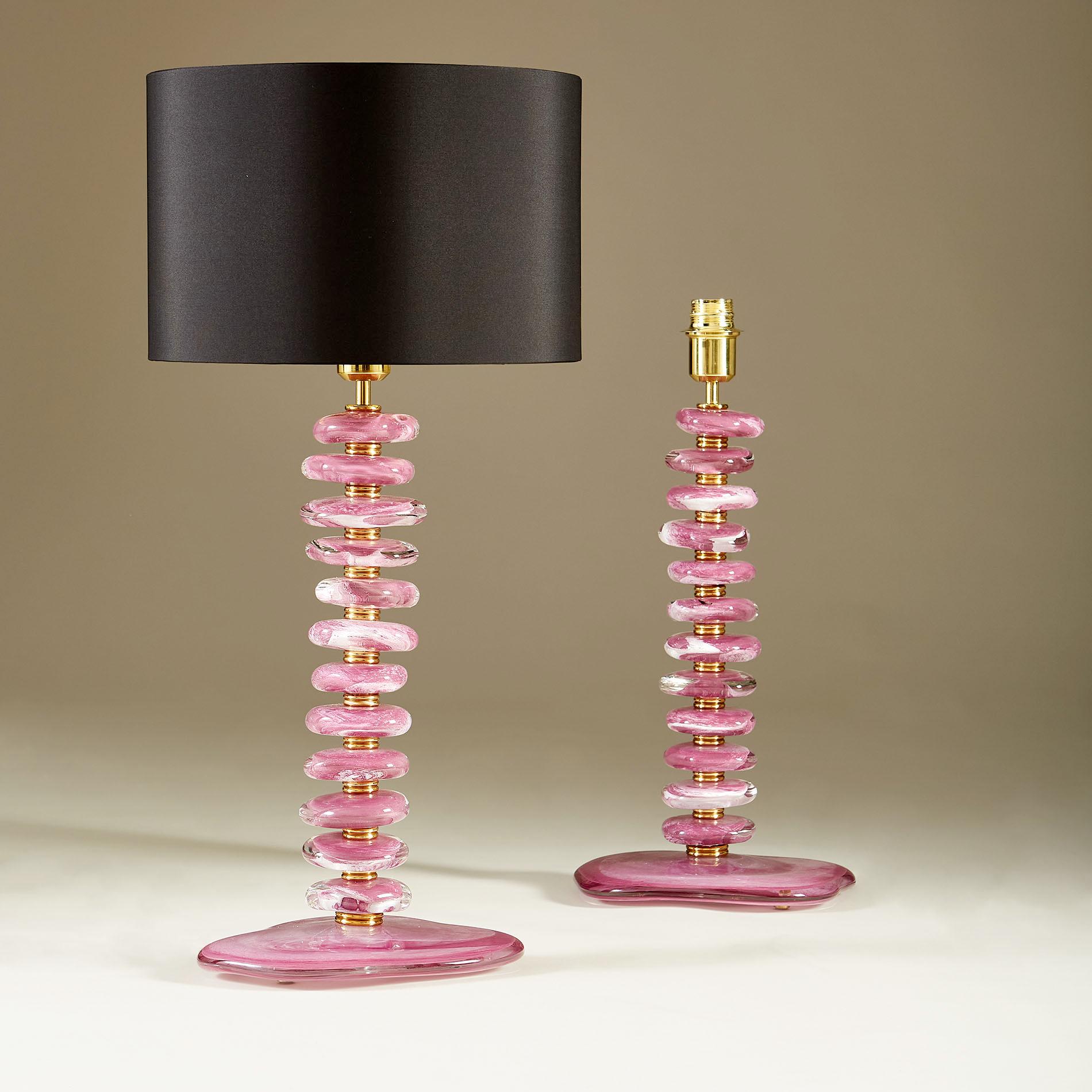 Una sostanziosa coppia di lampade da tavolo contemporanee. Ogni lampada è composta da 12 ciottoli scolpiti a mano e lisci, con tonalità rosa/viola e dettagli bianchi e trasparenti. Ogni ciottolo è intervallato da sezioni di ottone a doppia nervatura
