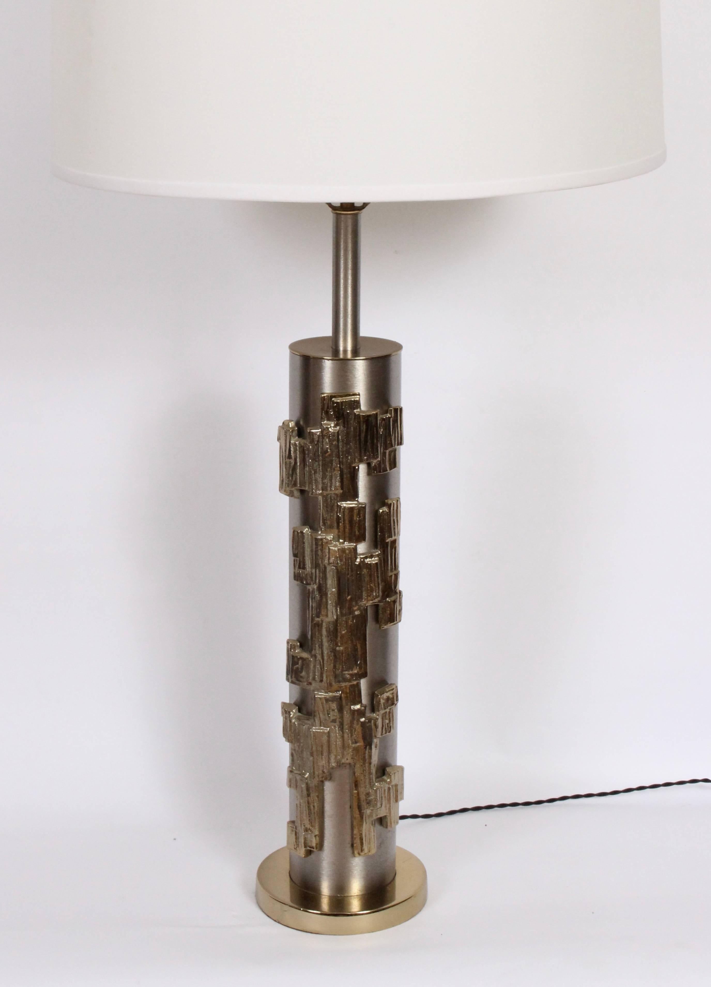 Substantial pair of Laurel Lamp Company textured brass and brushed steel table lamps, 1960s. Small footprint. Featuring a brushed steel cylinder, applied brass relief and round brass base. Bright. 29 H to top of socket. 21 H to top of cylinder.