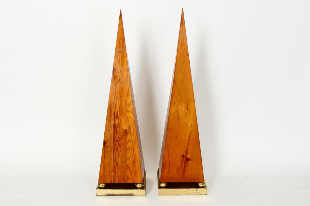 Pair of Knotty Pine Obelisks, Circa 1960's.  Featuring three solid panels of smooth, adhesed Knotty Pine with thin tipped pyramidal apex, atop 1.25H balanced square Brass box, bases accentuated with four 1