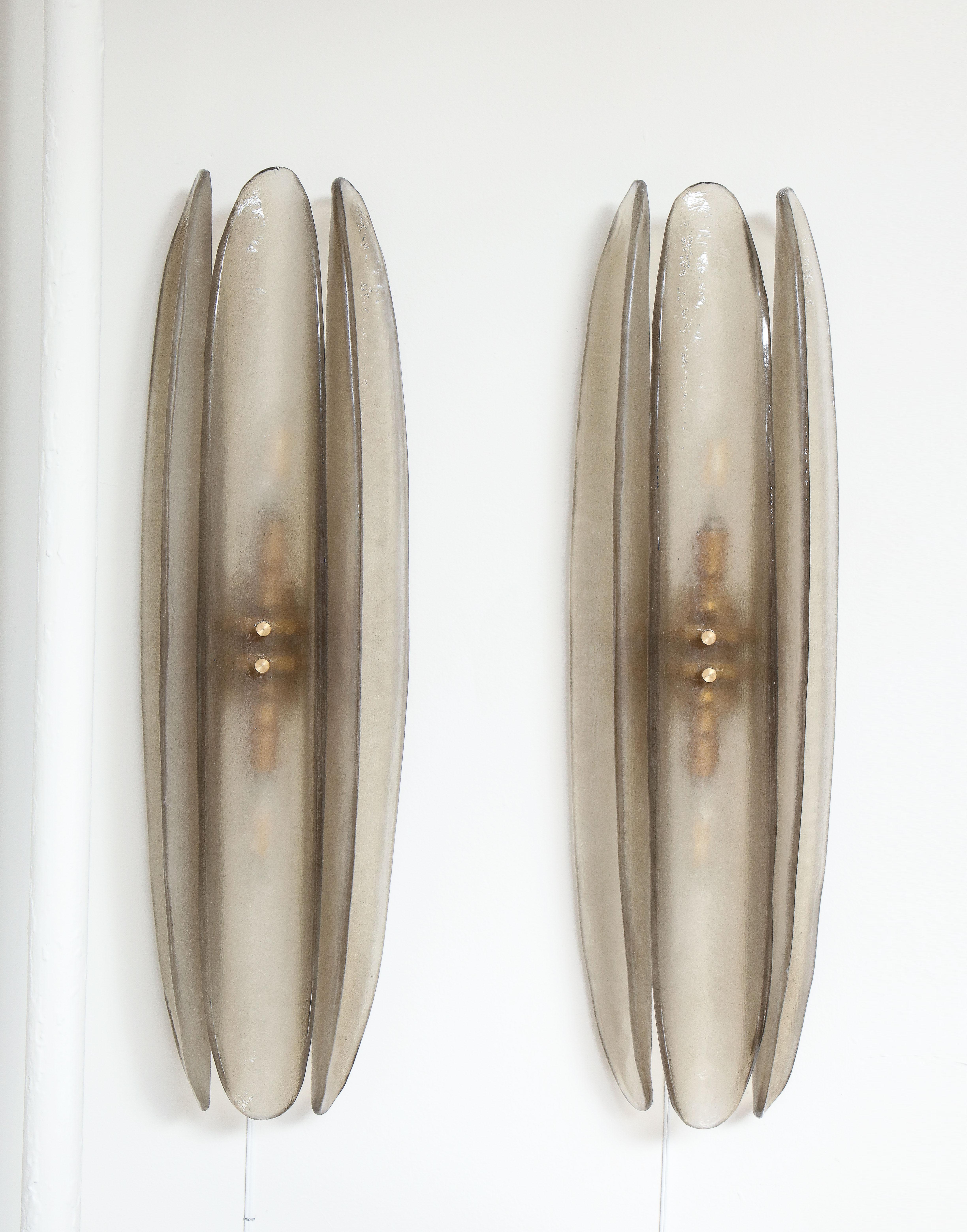 Tall and slender pair of smoked grey Taupe Murano Glass sconces consisting of 3 oval and concave glass elements mounted on a brass frame. The Murano Glass was hand-casted in a neutral, smoked grey taupe color which lends itself to a variety of
