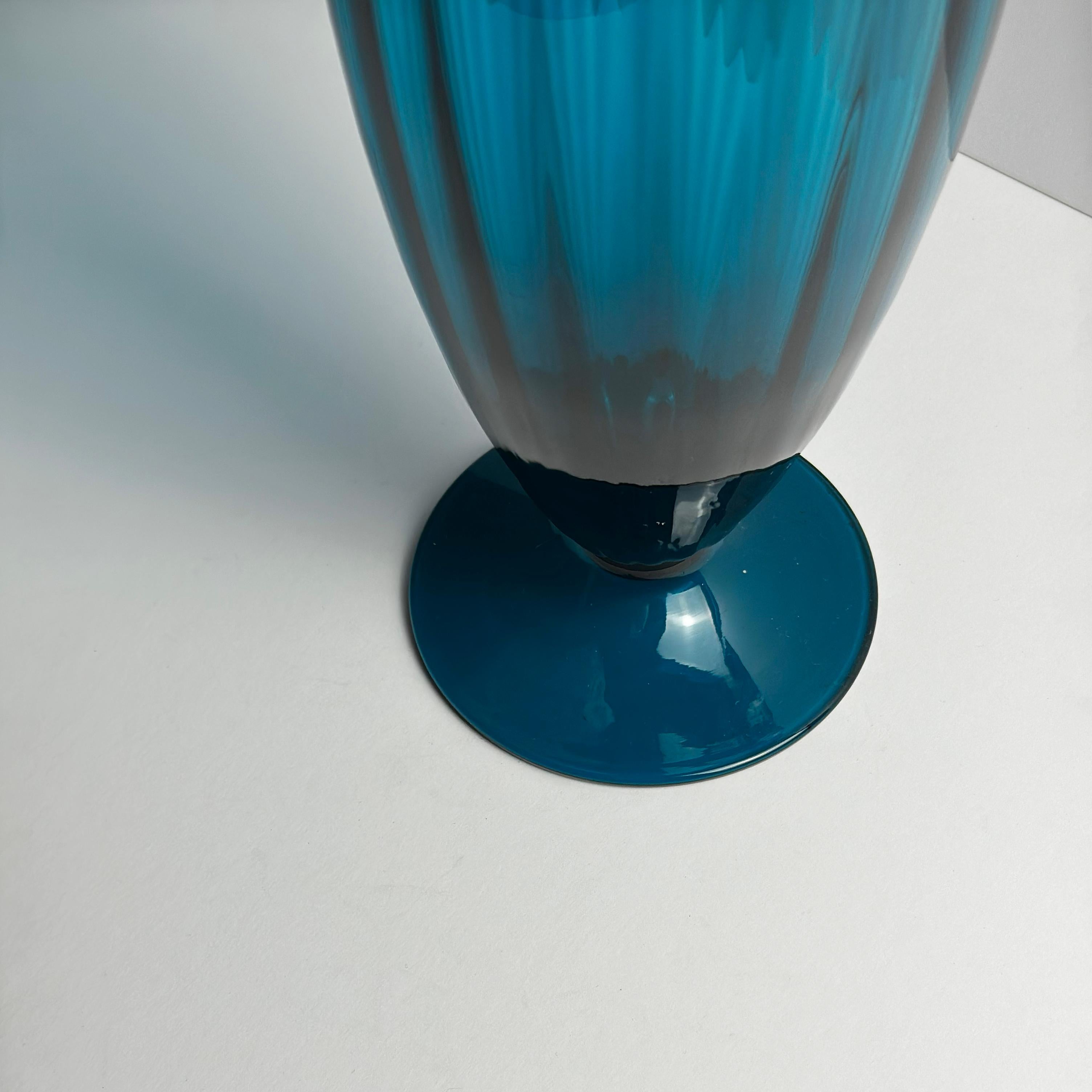 Eine hohe Vase aus pfauenblauem Kunstglas, mundgeblasen in Empoli, Italien, um 1960, die Rossini zugeschrieben wird - ein Name, der mit der Tradition der dekorativen Glasherstellung in der Mitte des Jahrhunderts in der Region verbunden ist.

Die