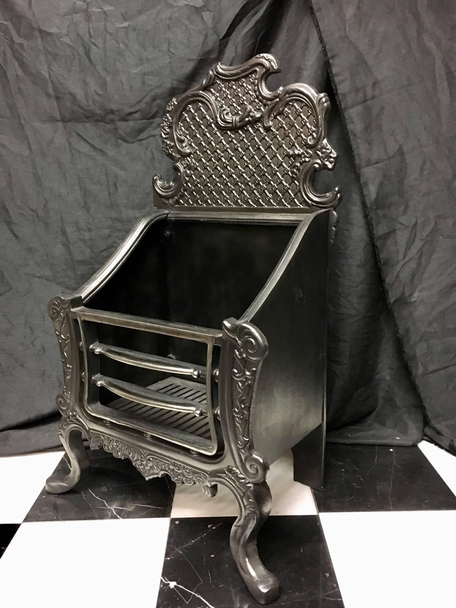 A period cast iron Rococo style fire grate in the ornate 18th century English Rococo manner of Thomas Chippendale. The tall 