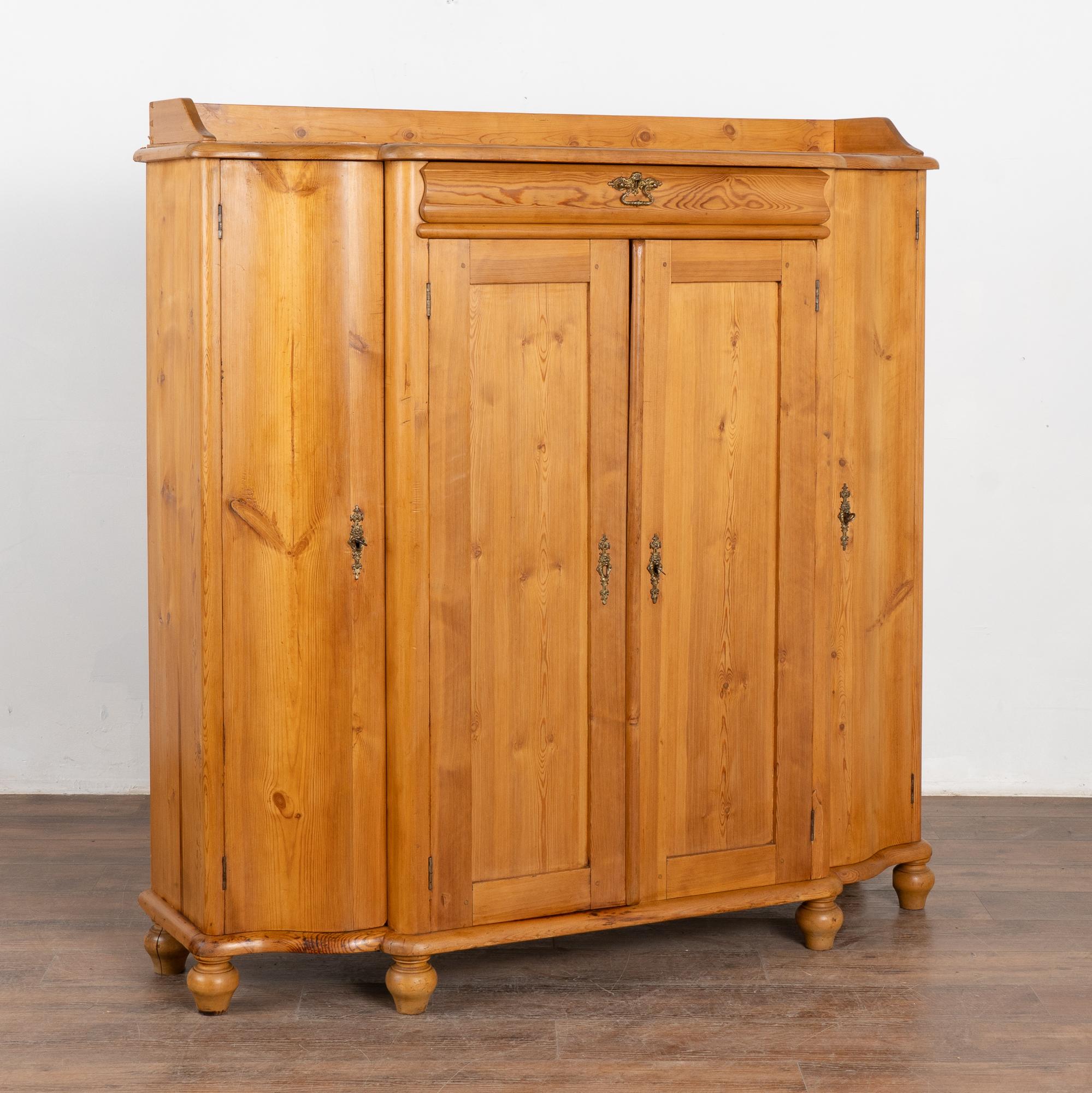 Credenza alta in pino svedese con bei lati curvi, un cassetto stretto e quattro ante.
Le lunghe ante curve rendono questo mobile un oggetto speciale, insieme al fascino della patina calda del pino invecchiato. 
Restaurato, questo mobile è forte,