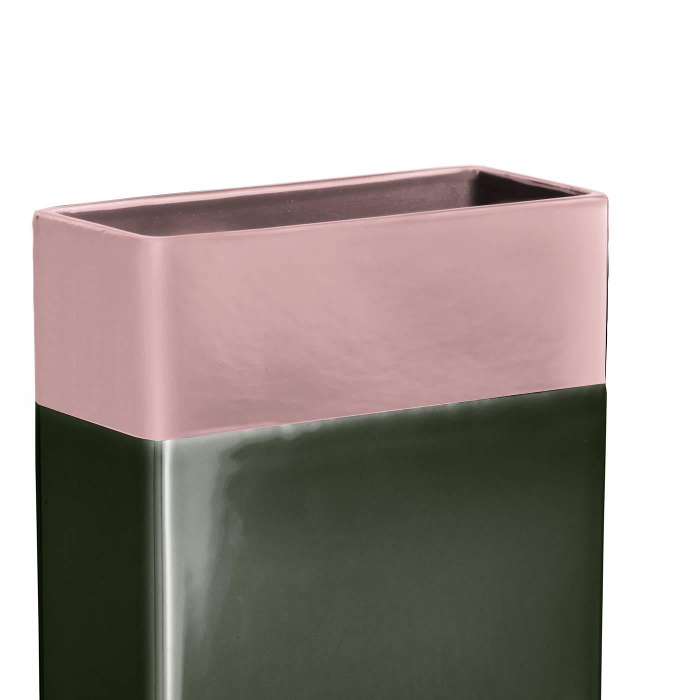 This modern vase features a striking tall rectangular construction and a contrasting color block pattern which was applied by hand. The top section of the vase is glazed in a delicate pink while the body is covered in a bold green glaze. The base of