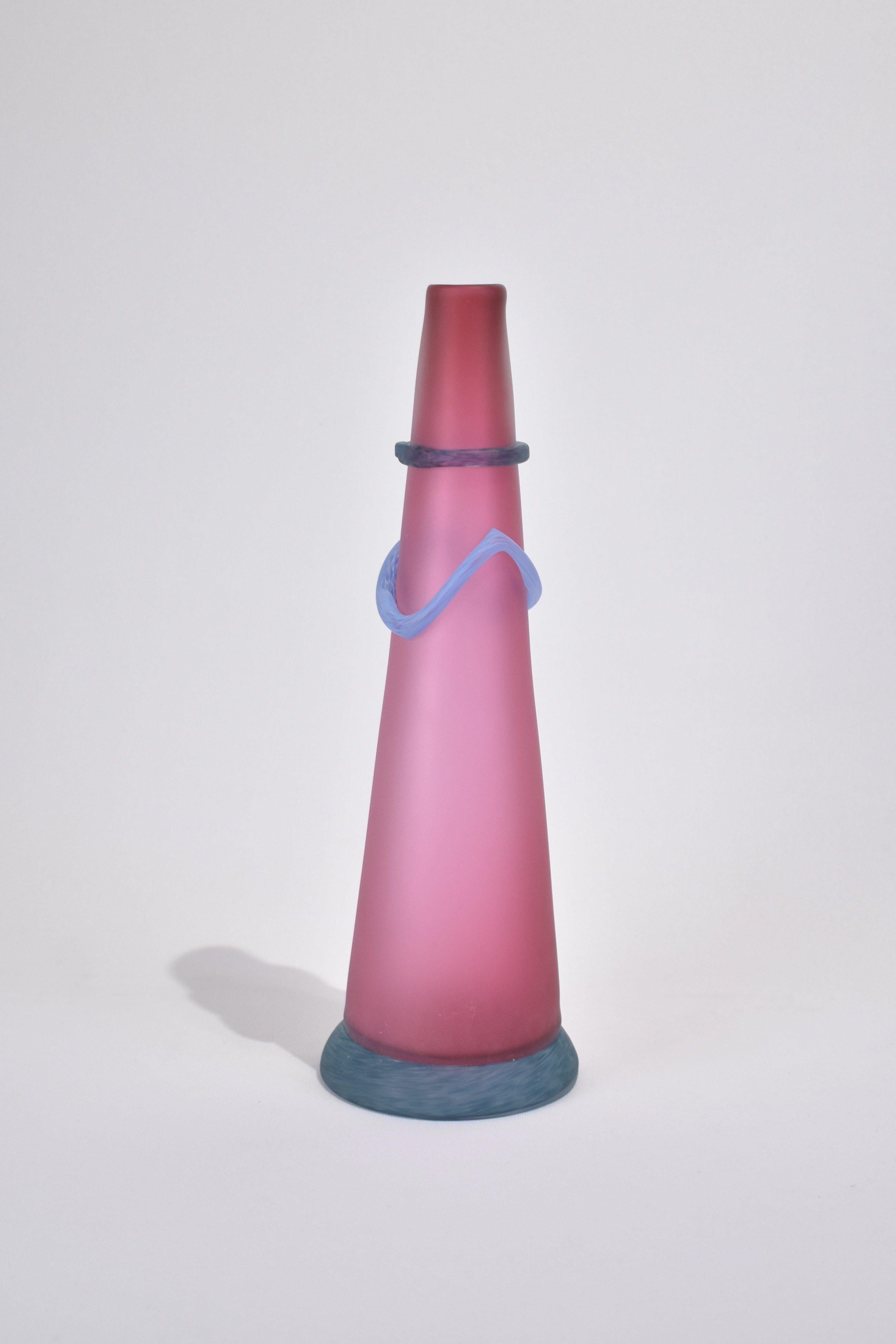 Hand-blown, satin pink art glass vase in a tall cone shape with blue wrap detail and base. Signed on base.