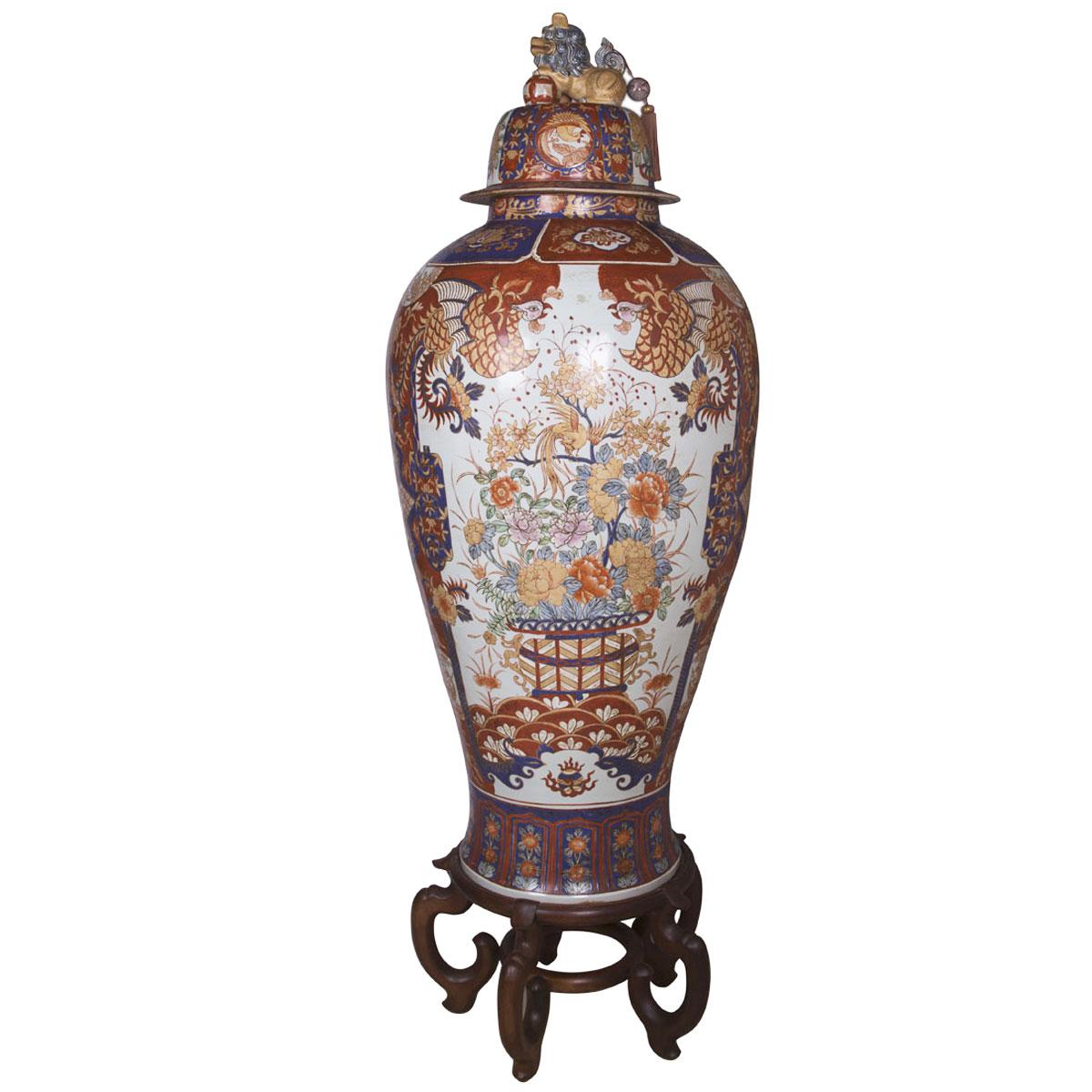 This hand painted tall Imari style vase is made of porcelain. The removable porcelian lid at the top features Fu Dog which is a strong feng shui protection symbol. Wooden stand is includes for this item. This vase measures 66 inches in height and