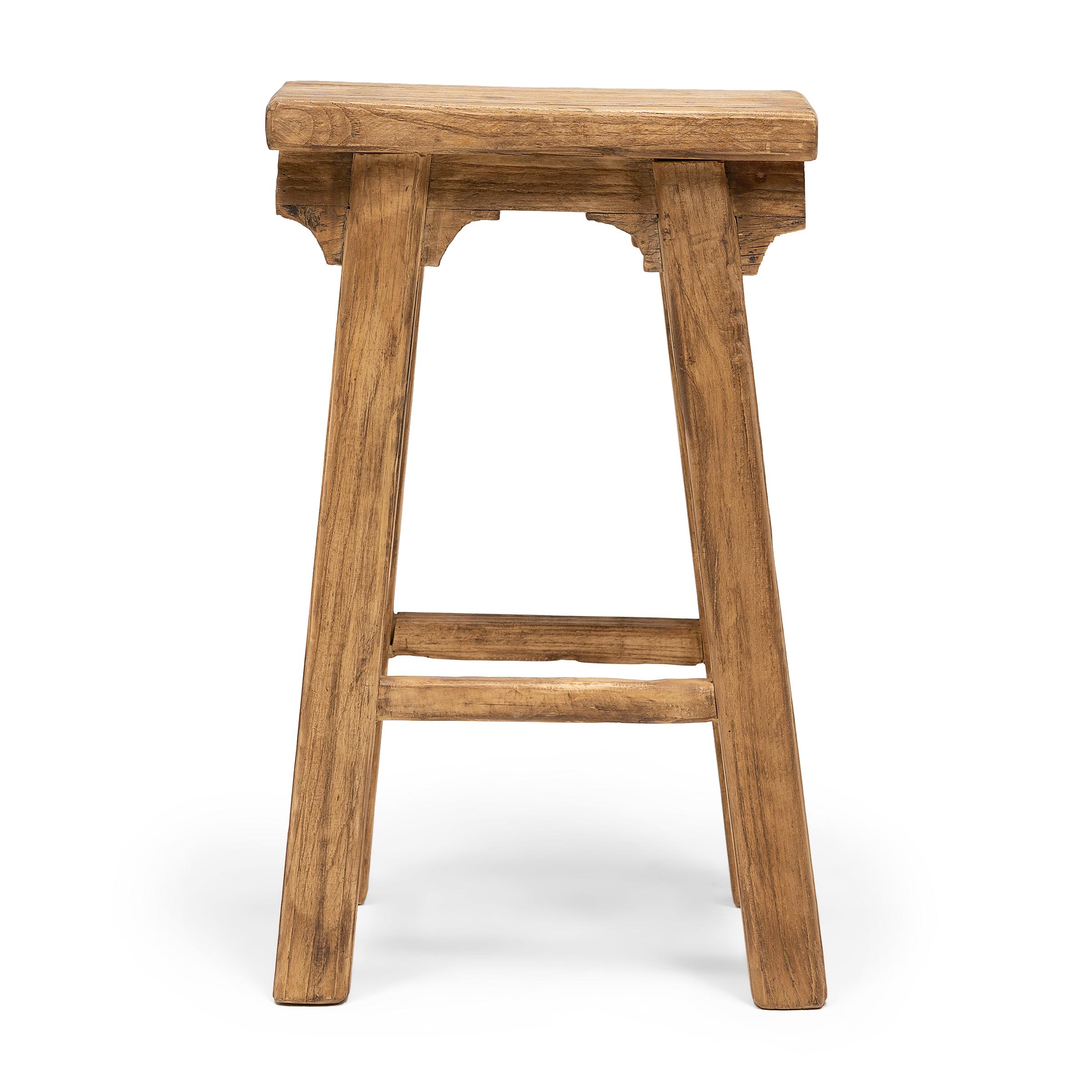 This provincial stool is artisan-crafted in the style of traditional Chinese courtyard stools typically used throughout a Qing dynasty home as versatile everyday seating. Made of reclaimed elmwood, the tapered stool features a narrow, rectangular