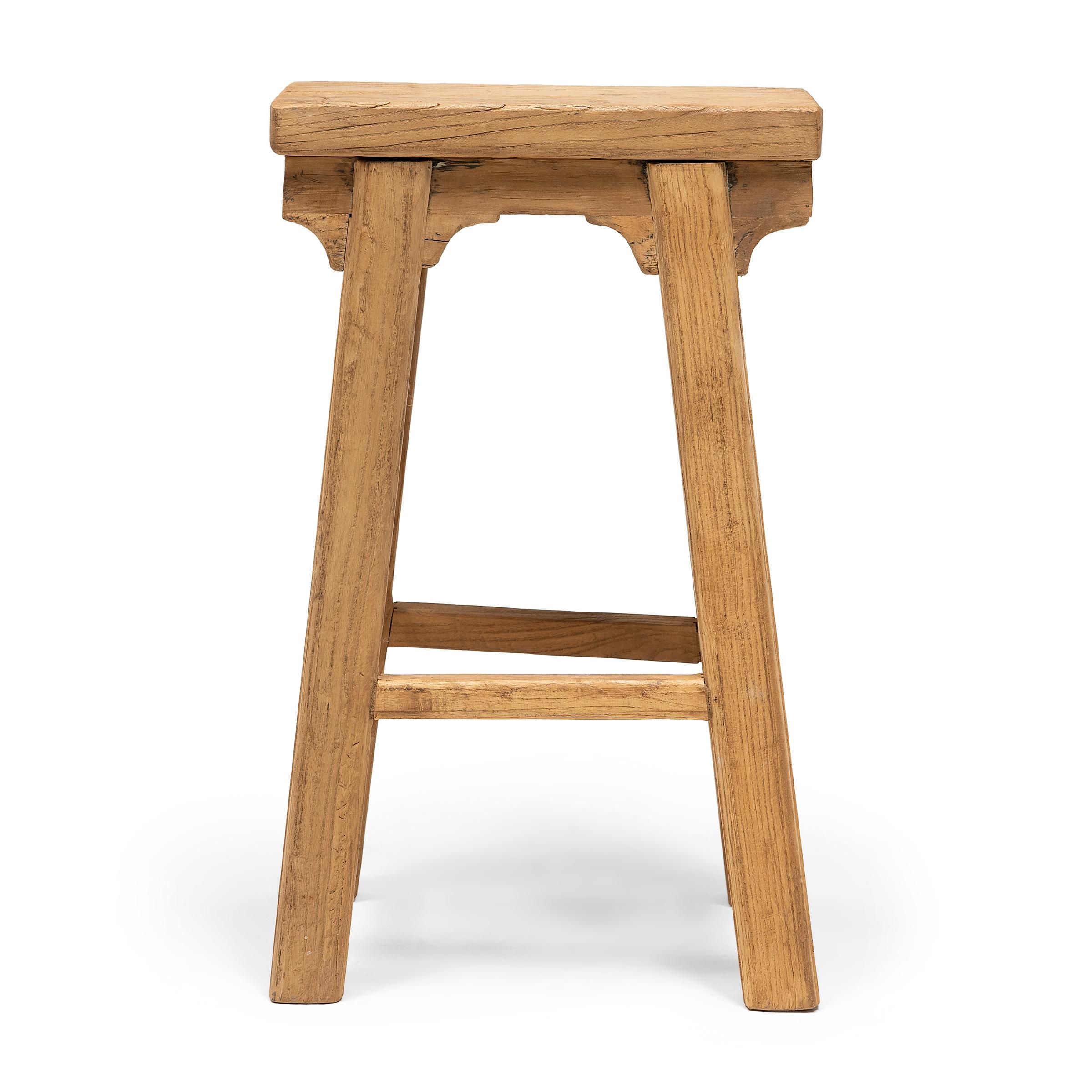 This provincial stool is artisan-crafted in the style of traditional Chinese courtyard stools typically used throughout a Qing dynasty home as versatile everyday seating. Made of reclaimed elmwood, the tapered stool features a narrow, rectangular