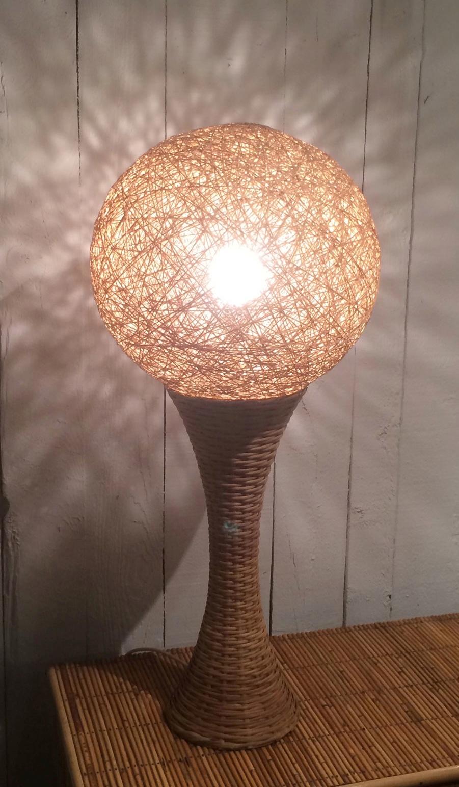 This tall and decorative table lamp is made of rattan. This is a nice French work, circa 1970