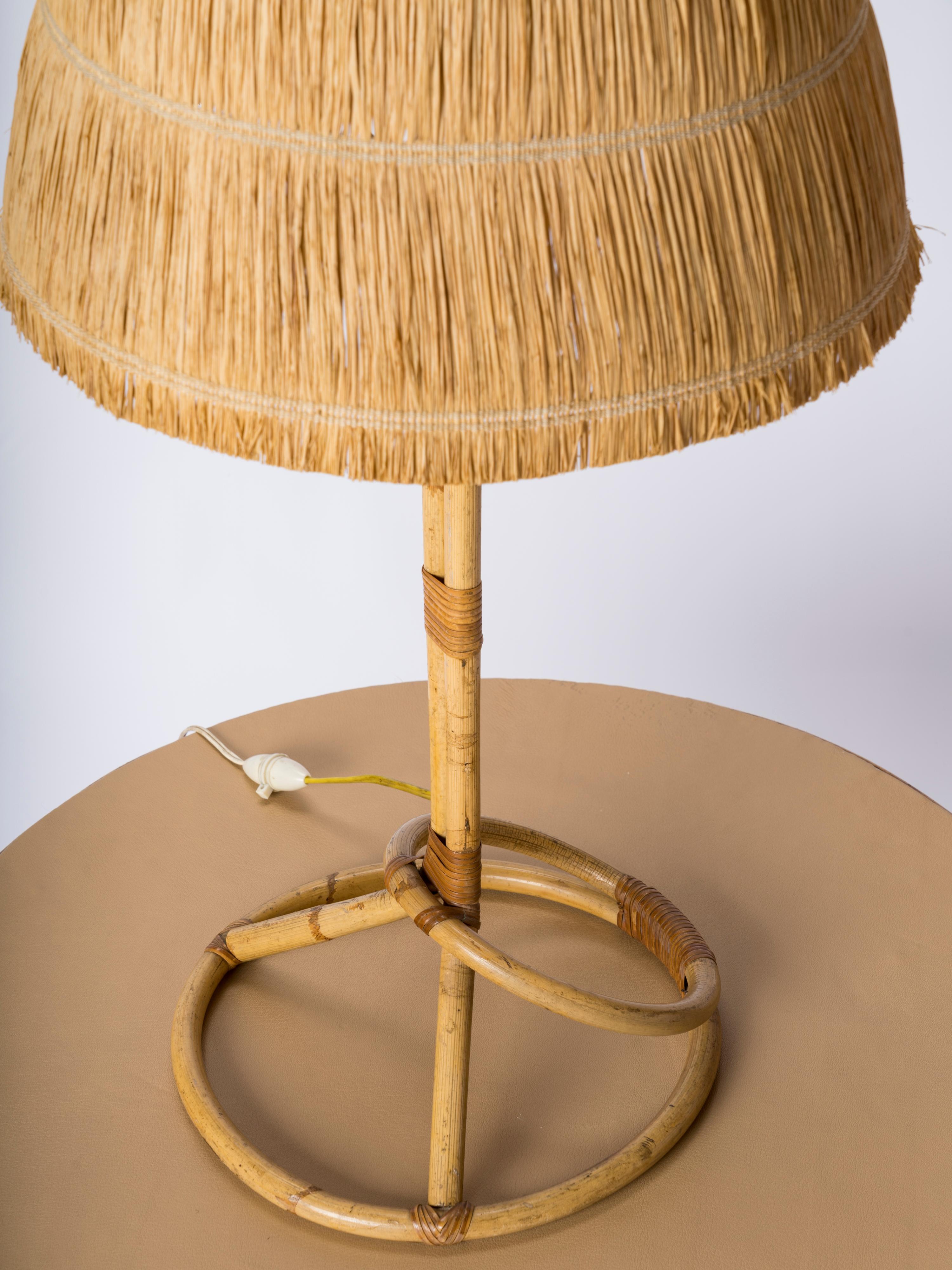 Rare big size table rattan lamp with original raffia shade. France 1950's. In the style of Louis Sognot. Good vintage condition. Needs to be rewired for use in the US.  
Height ex shade is 49cm or 19.3