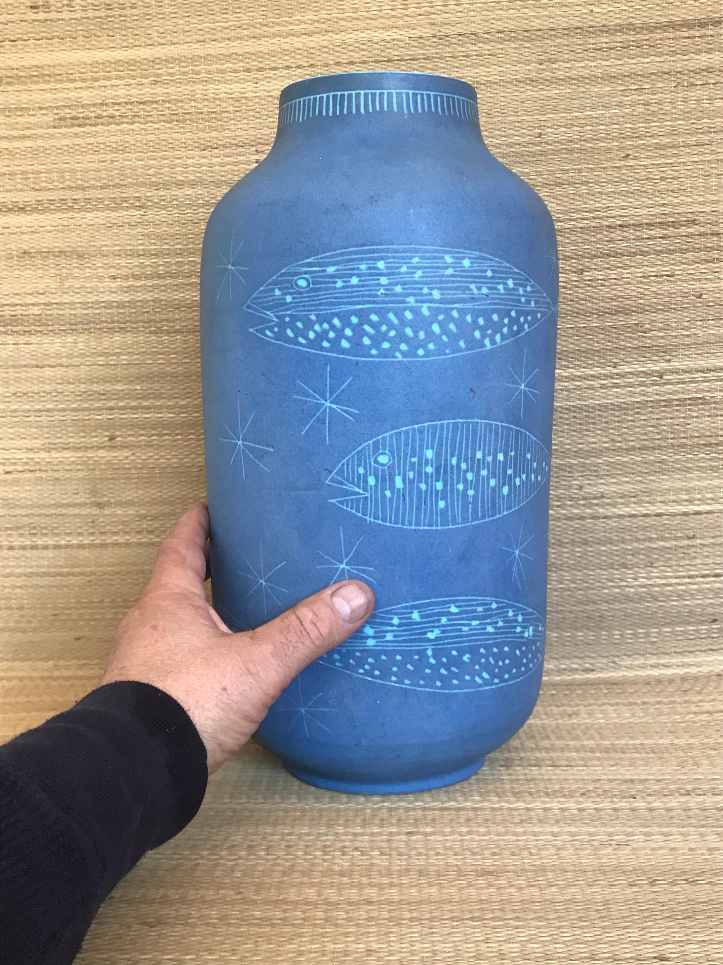 Great scale
Amazing periwinkle mat glaze
Fun hand carved aquatic design
A strong piece that can stand by itself as a decorative element or with flowers and branches
(one small tight hairline crack inside the rim, does not go through to the