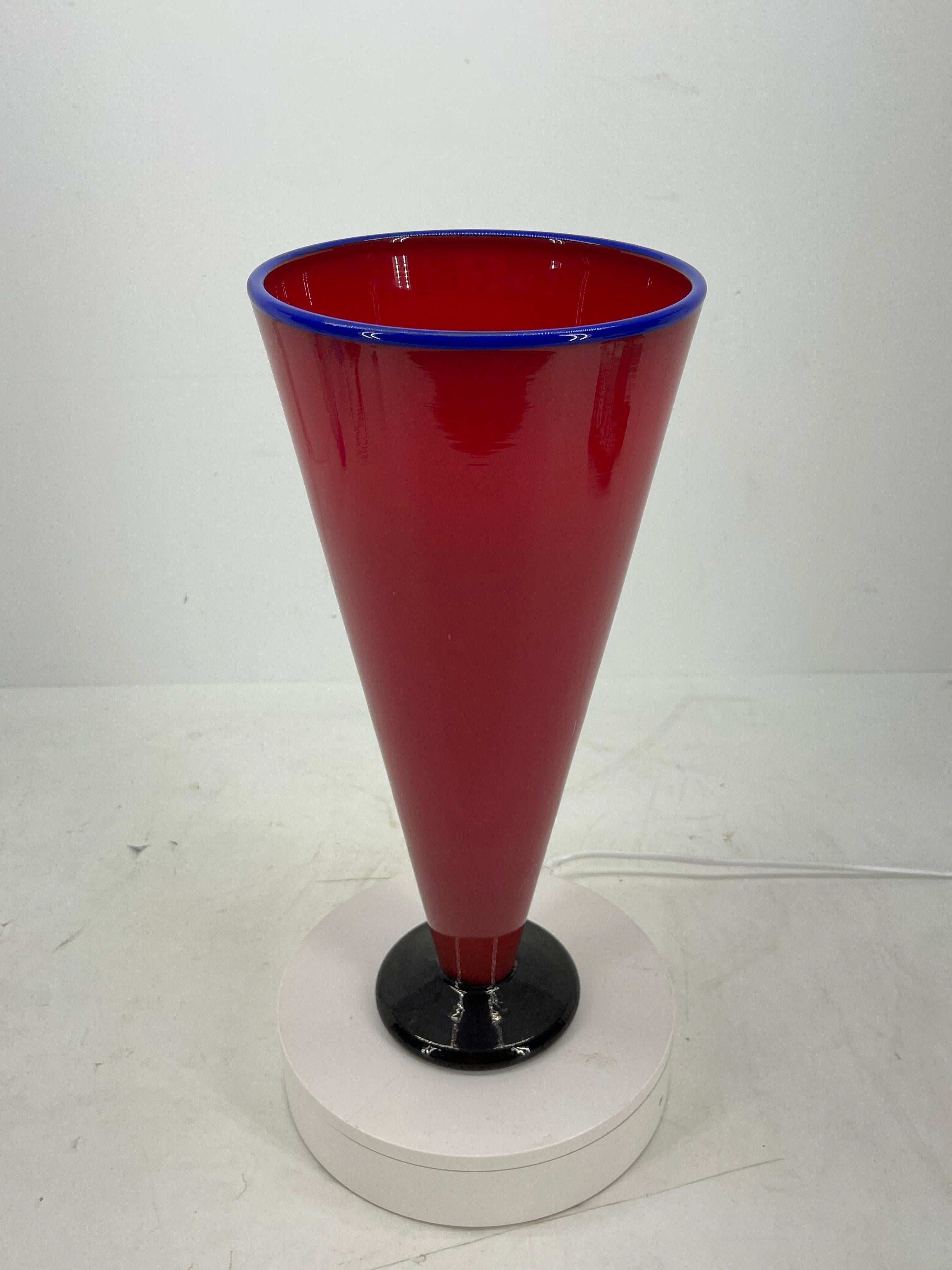 Modern red and blue handblown glass vase. This tall vase is rich red with cobalt blue colored rim. The black base meets the red glass making the vase striking and modern. It is large enough to grace a table as a centerpiece or display anywhere you