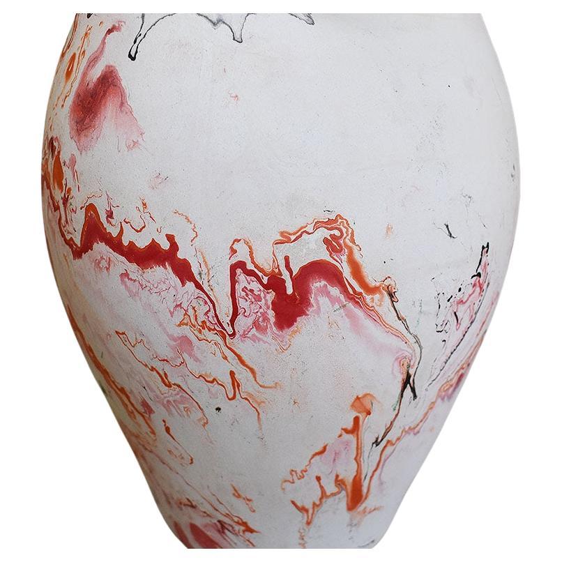 A midcentury-style touring pottery piece. It has a wide body and two spouts. It is created from Native Indian clay in a marbled black, red, and orange. 

Bottom reads:
Nemadji Pottery
USA

Dimensions:
10.5