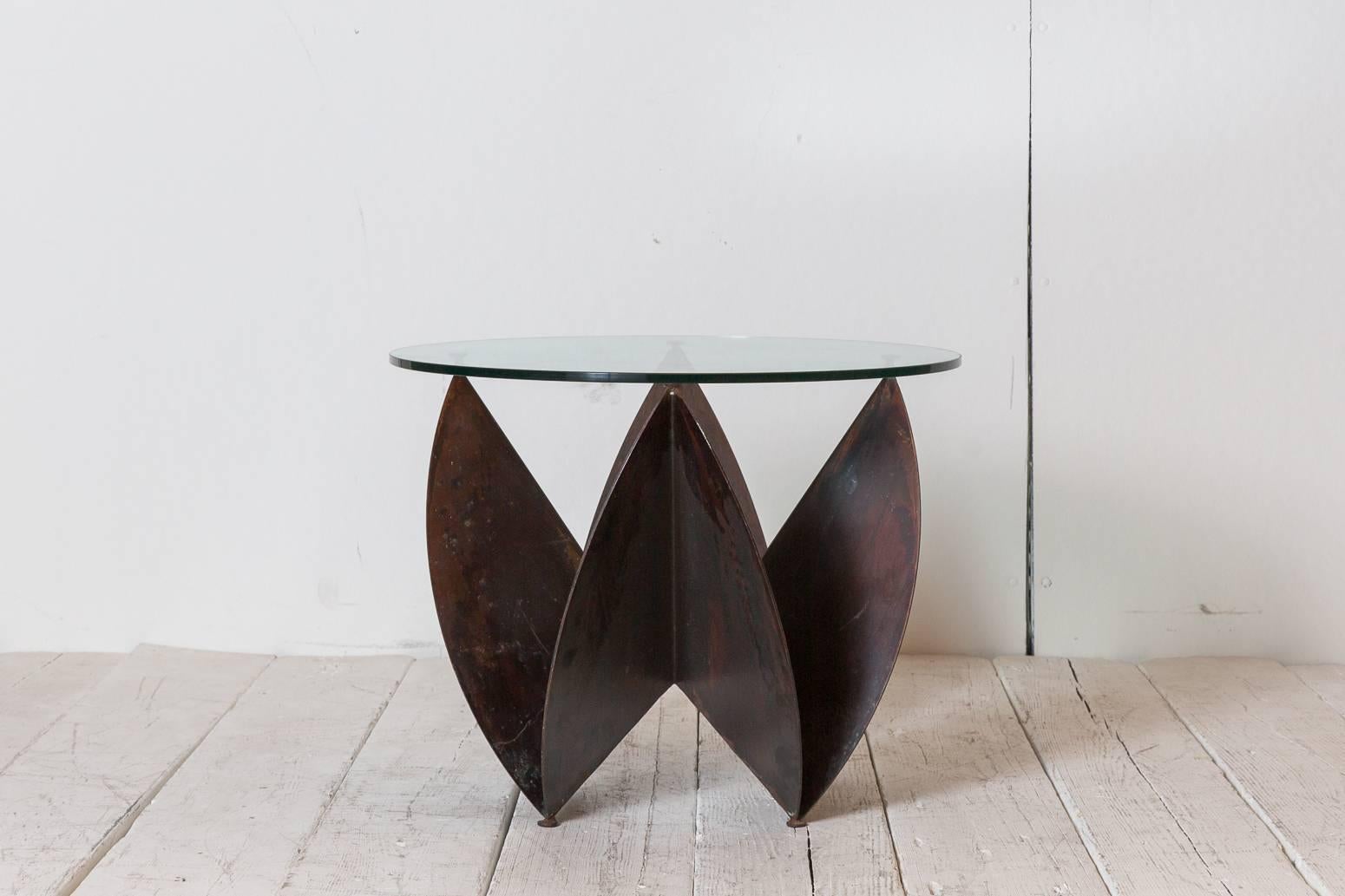 Tall sculptural copper side table with round glass top.