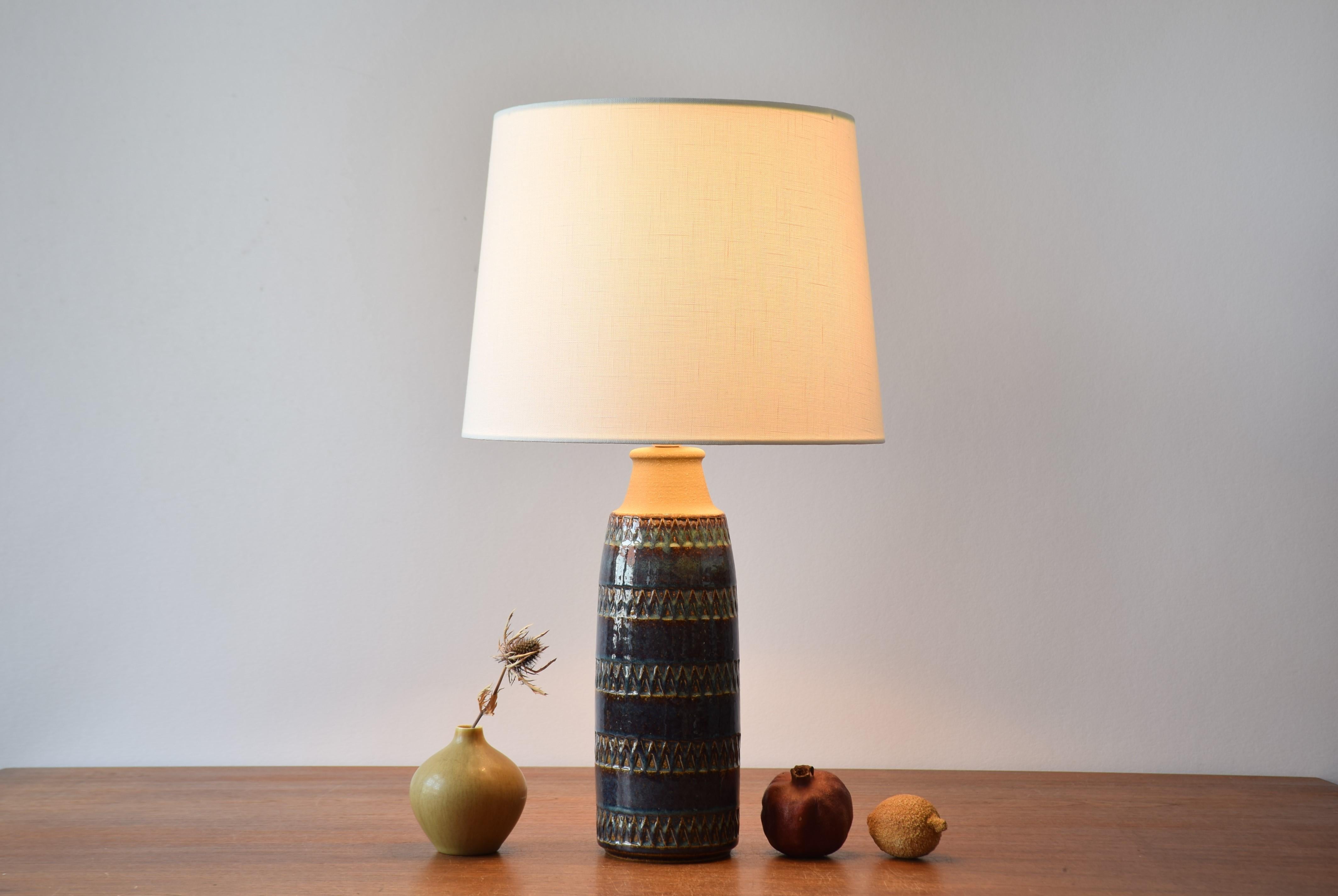 Tall table lamp from Søholm Stentøj, Denmark, circa 1960s.
The glaze is blue with caramel brown elements. The neck is unglazed and shows the warm sand colored clay color.

Included is a new lamp shade designed and made in Denmark. It is made of