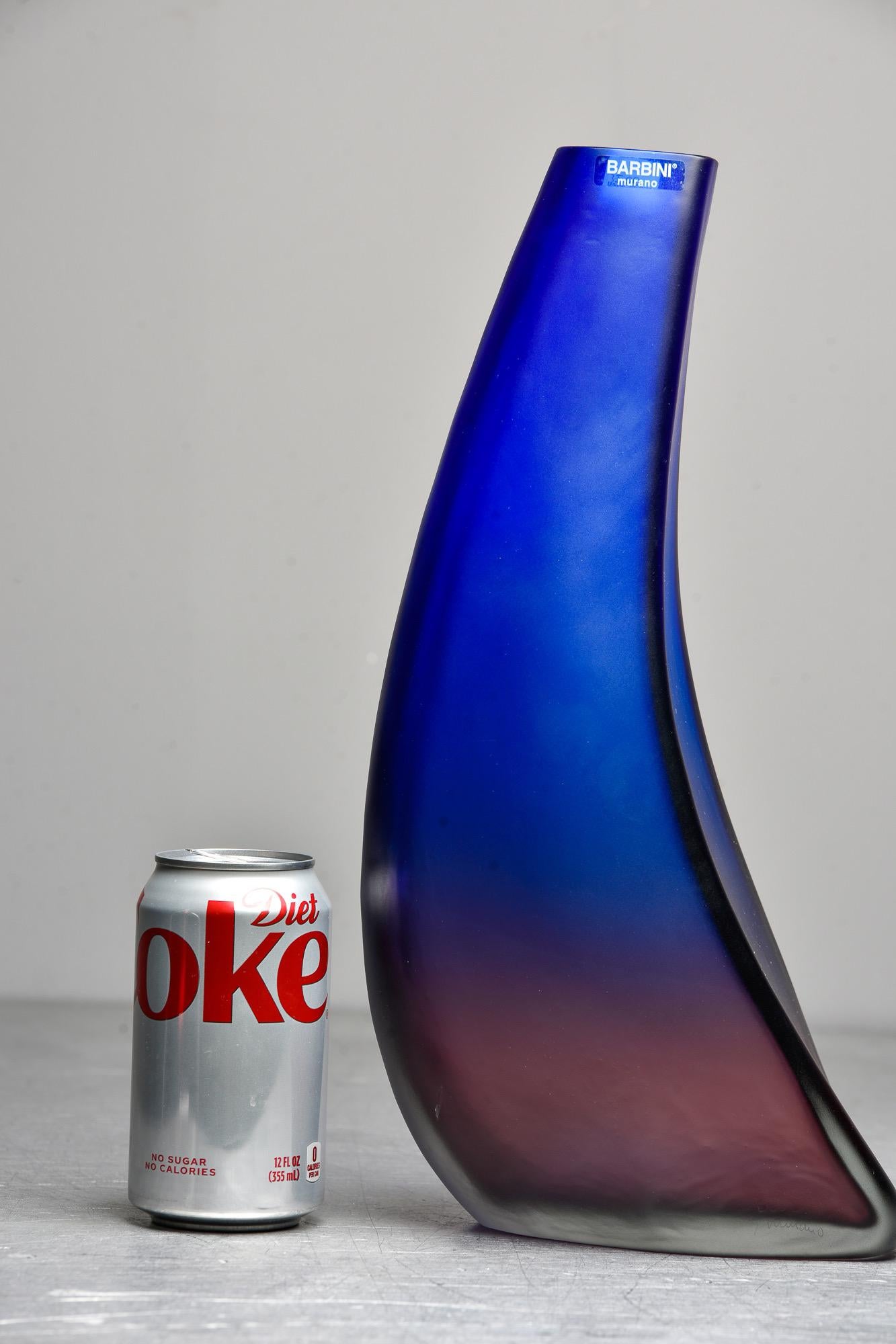 Circa 2010 Barbini of Murano tall, curved glass vase in ombre style that transitions from rich cobalt blue at top to deep amethyst at base. Original label affixed and signature is etched on base. Unused condition.