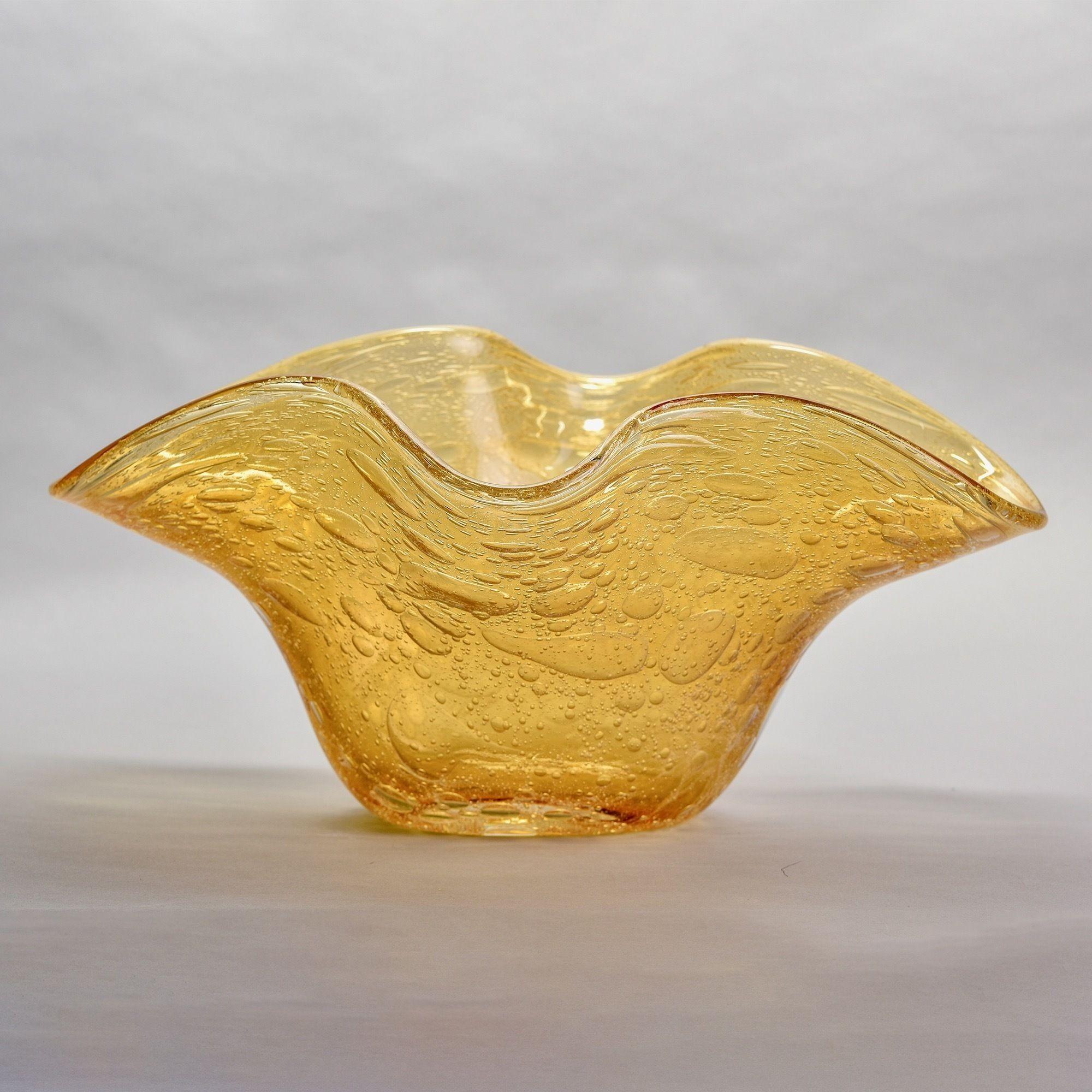 Circa 1990s extra large Murano glass bowl in a medium, warm gold tone is 20” wide and over 14” tall. Wavy rim and lots of internal air bubbles add visual flair. Original Murano label still affixed with glassworks code 036 which is Artigianato