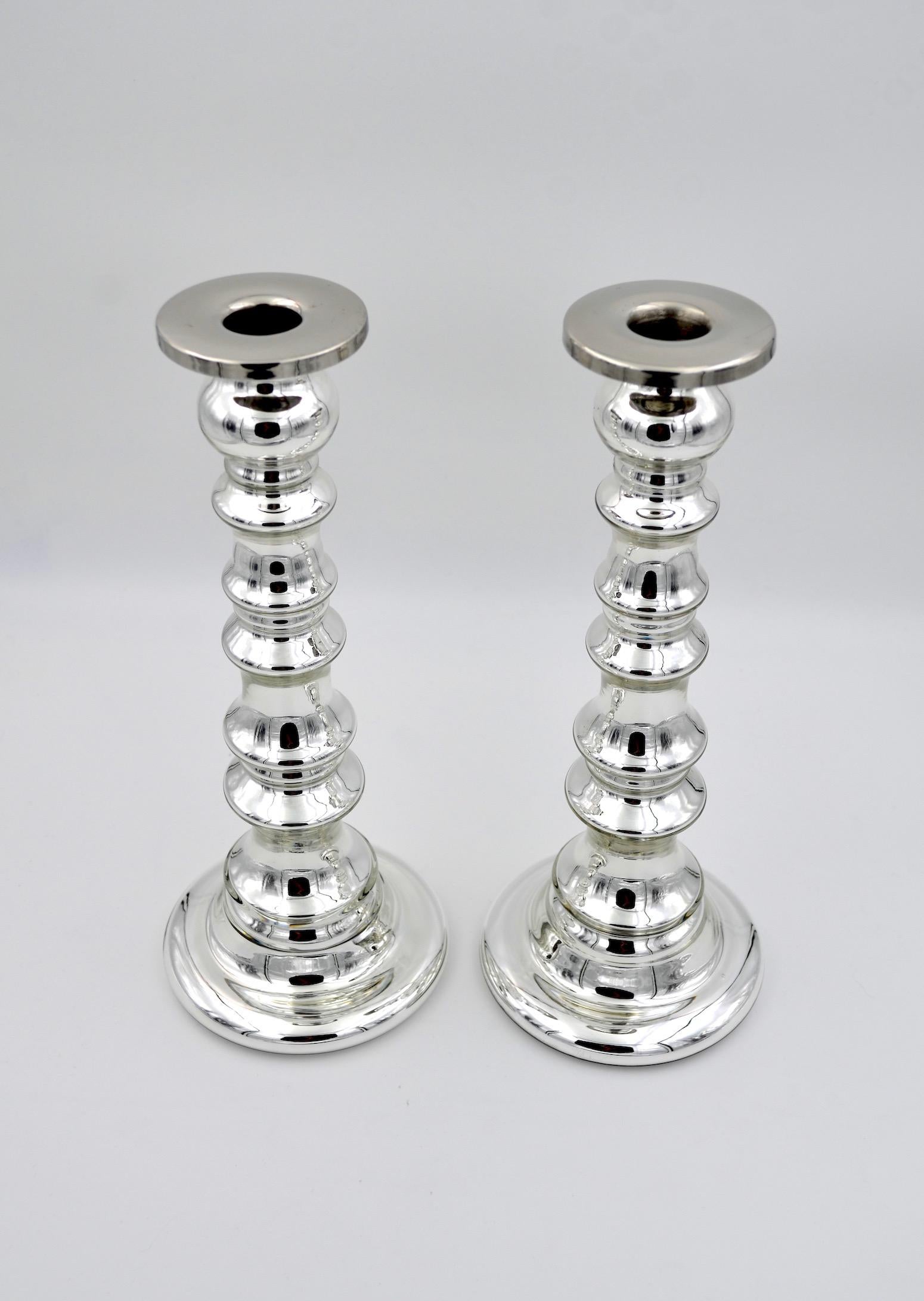 A tall and sculptural pair of vintage candlesticks in silvered mercury glass with metal candle cups. The silvered glass candle holders are a perfect finishing touch to any Art Deco or Hollywood Regency interior decor scheme. 

The stem of each