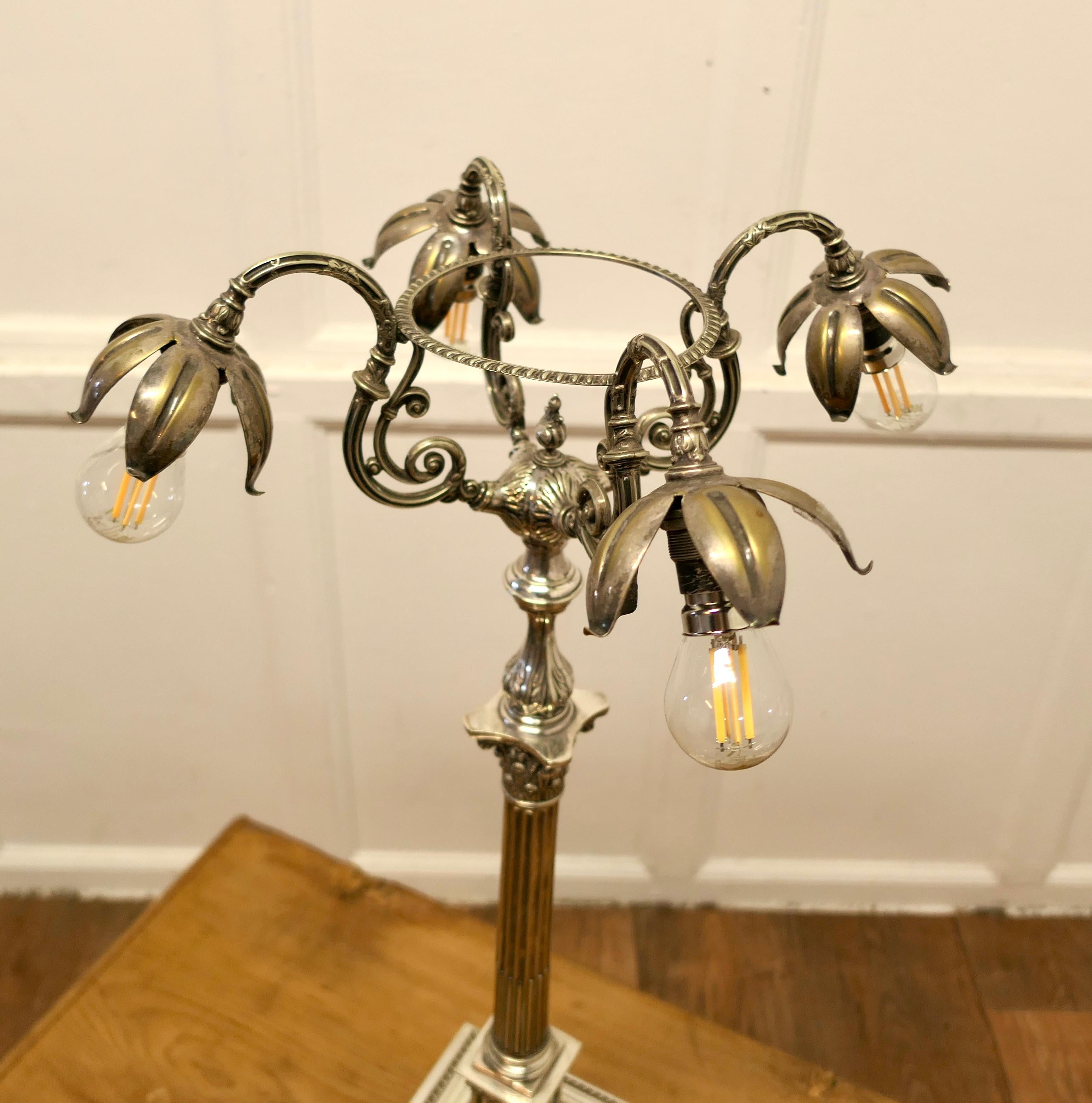Tall Silver Plated Table Candelabra Sideboard Lamp

This is a very unusual piece, the lamp is made in heavy silver-plate, it is set on a square stepped base with a tall column supporting 4 lamps set with petal-like shades
The lamp has new wiring and