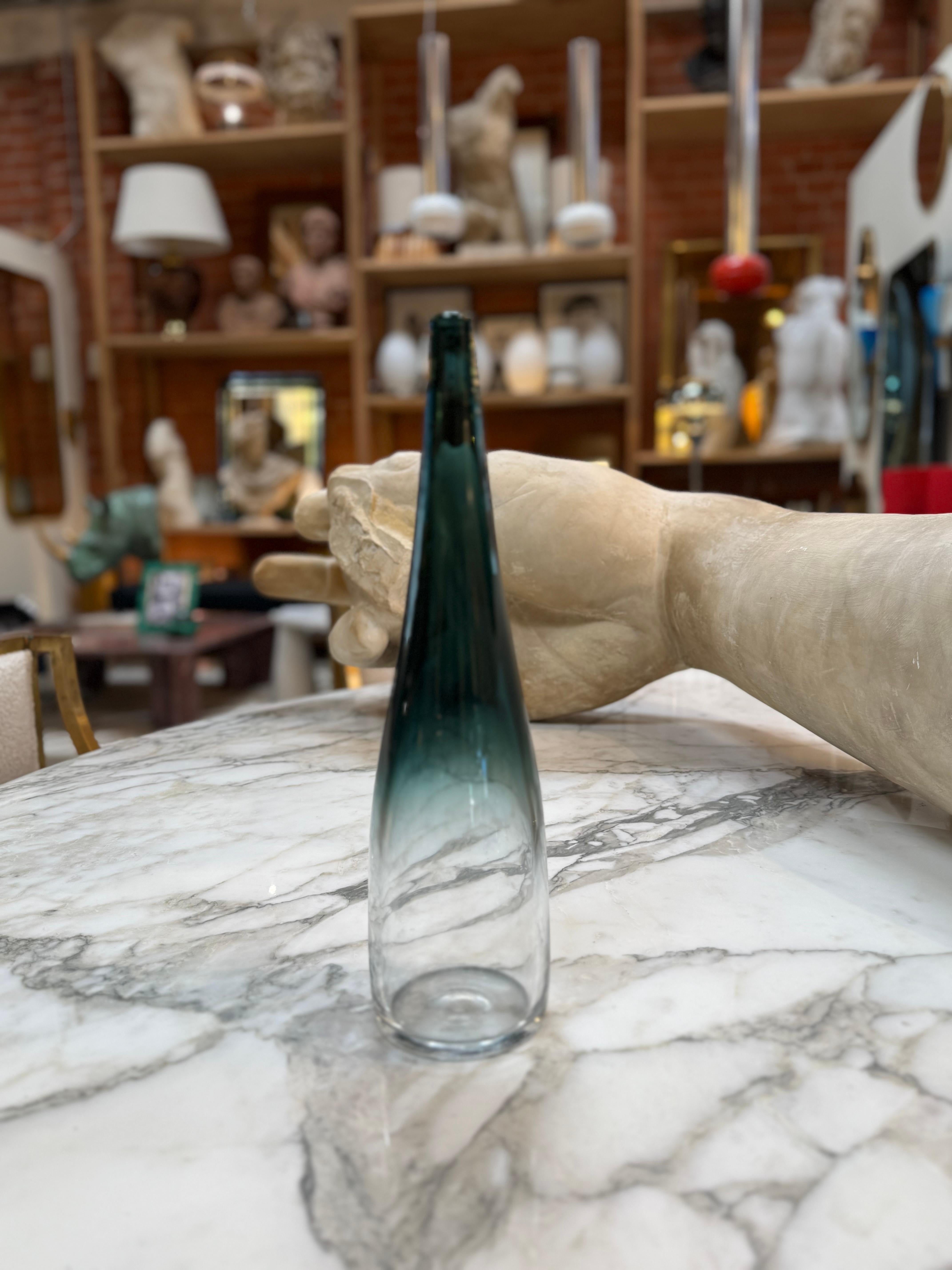 Vase élégant en verre d'art de Murano, à la silhouette haute et élancée, qui se rétrécit gracieusement jusqu'à une ouverture étroite. Le verre passe d'une teinte claire à la base à une teinte charbonneuse vers le haut, créant un effet de dégradé