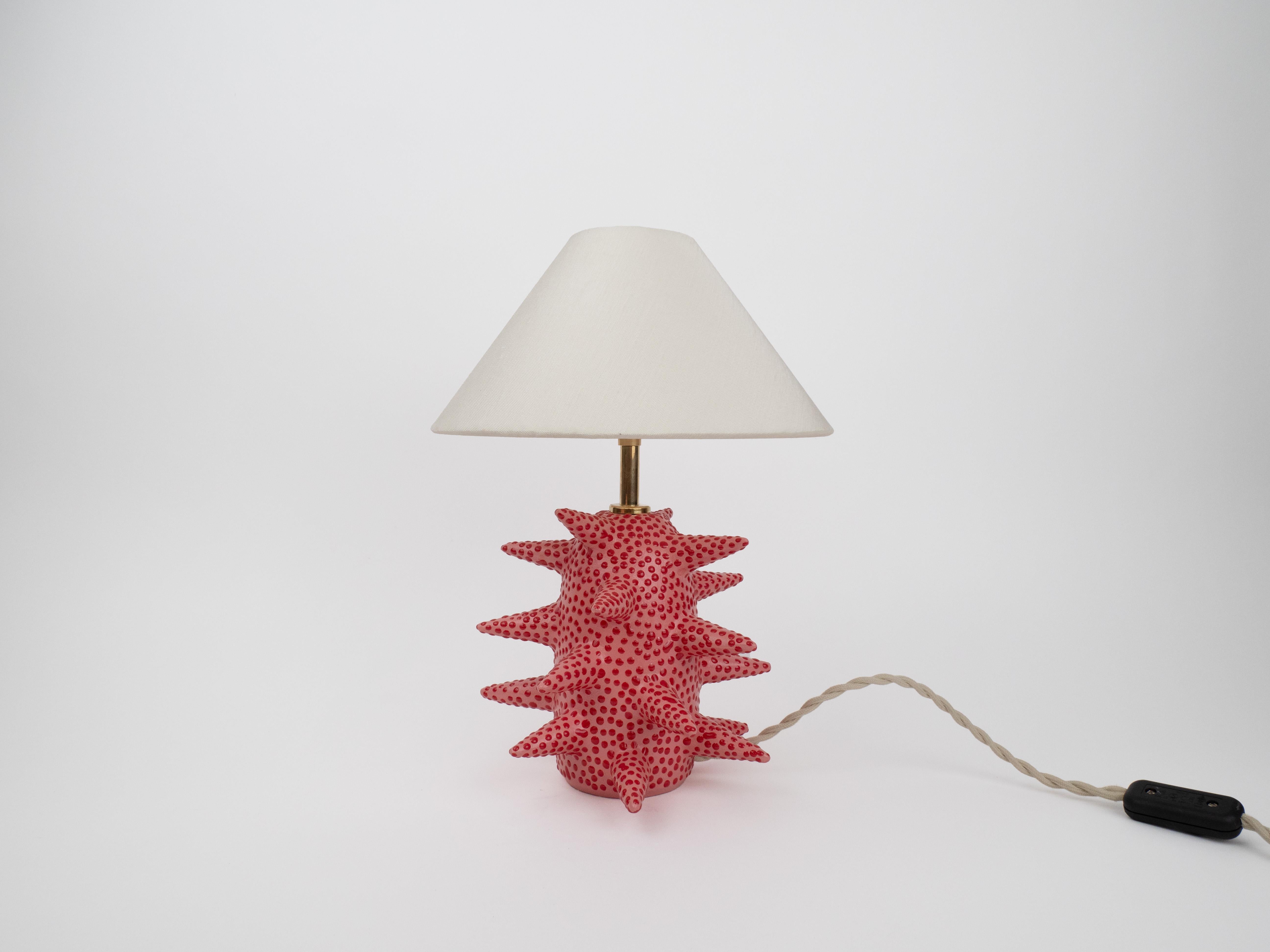 Ajoutez une touche ludique à votre décor avec cette base de lampe à pointes unique. Avec une sous-couche rose et des pois rouges audacieux, il allie fantaisie et modernité. Les pointes frappantes font une déclaration audacieuse, tandis que les