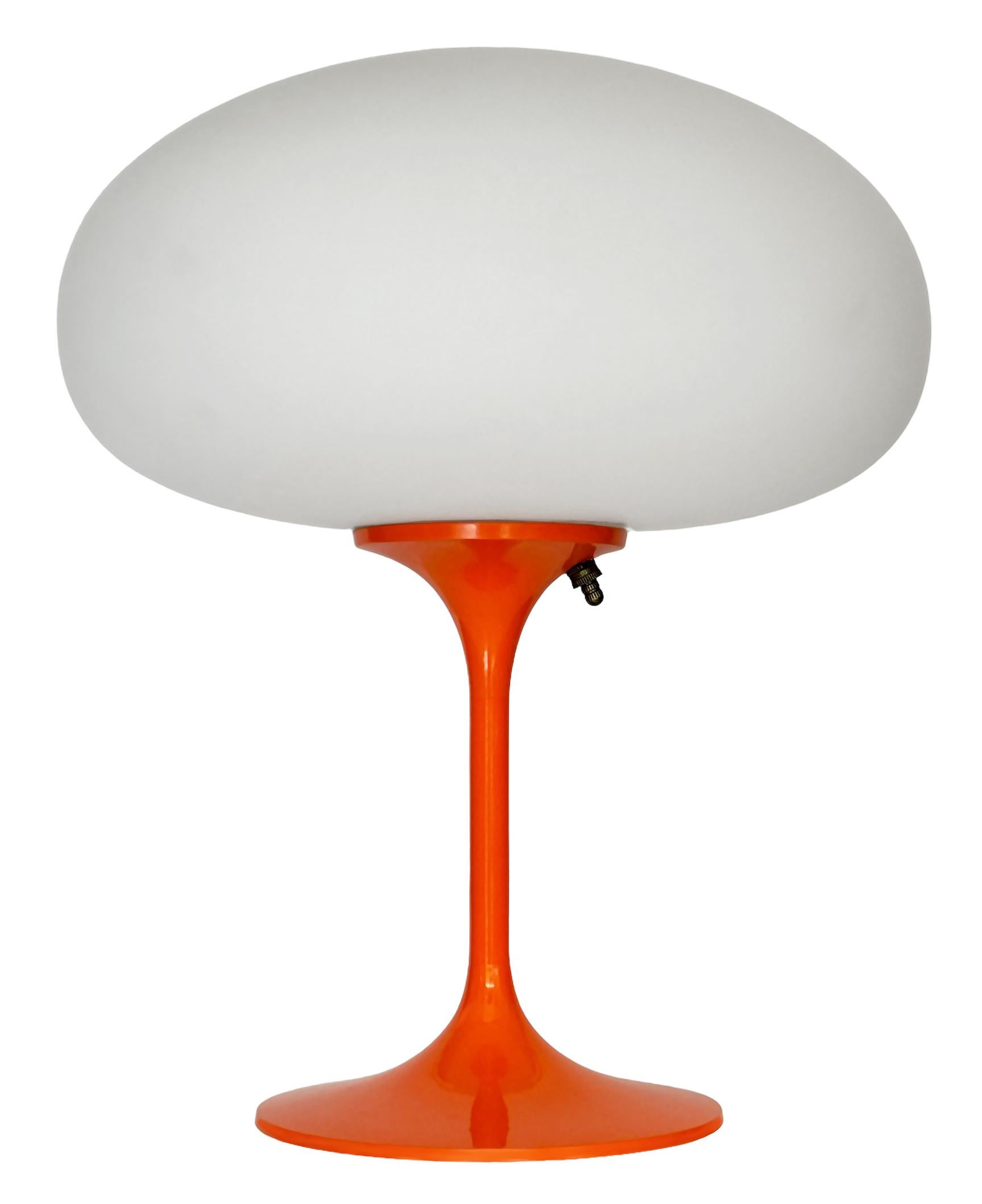 DIESER ARTIKEL IST VERSANDKOSTENFREI!

Eine elegante Stemlite-Tischleuchte von Design Line. Sie verfügt über einen Aluminiumguss-Sockel in einer skulpturalen Tulpenform. Der Sockel der Leuchte ist in einem klassischen Retro-Orange gehalten. Der