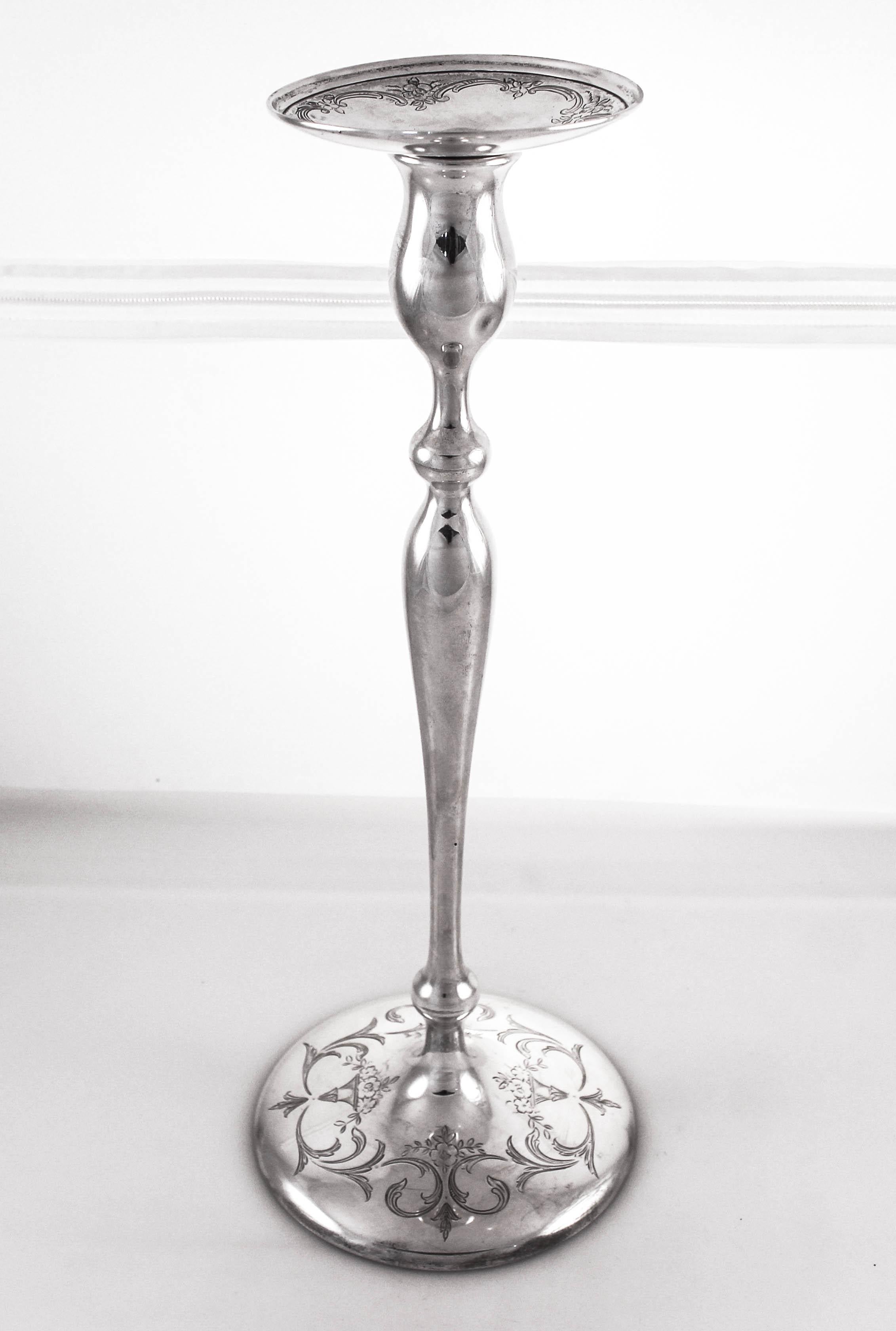 An exceptional pair of sterling silver candlesticks by Shreve Crump and Low of San Francisco. Delicate etching can be found around the base and bobeche. They are very tall and have a feminine silhouette. Curves and a tapered bottom that make them so