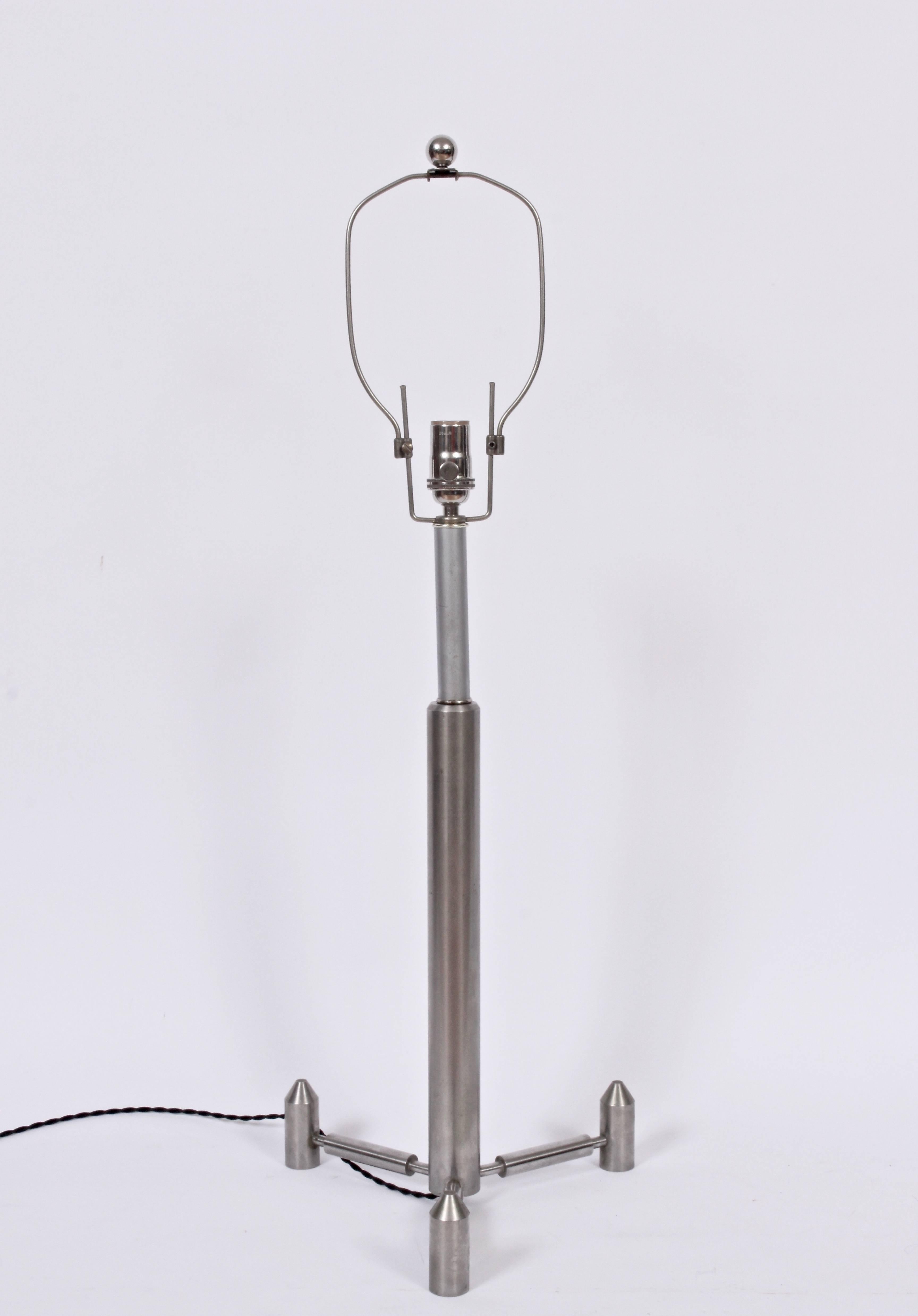 Tall Studio Machined Aeronautic Brushed Steel Table Lamp. Featuring a Tripod  handcrafted rocket form on footed Tripod base. Original adjustable harp; shifts up and down 3 inches. Harp shown in upright position. 25H to top of socket. Shade shown for