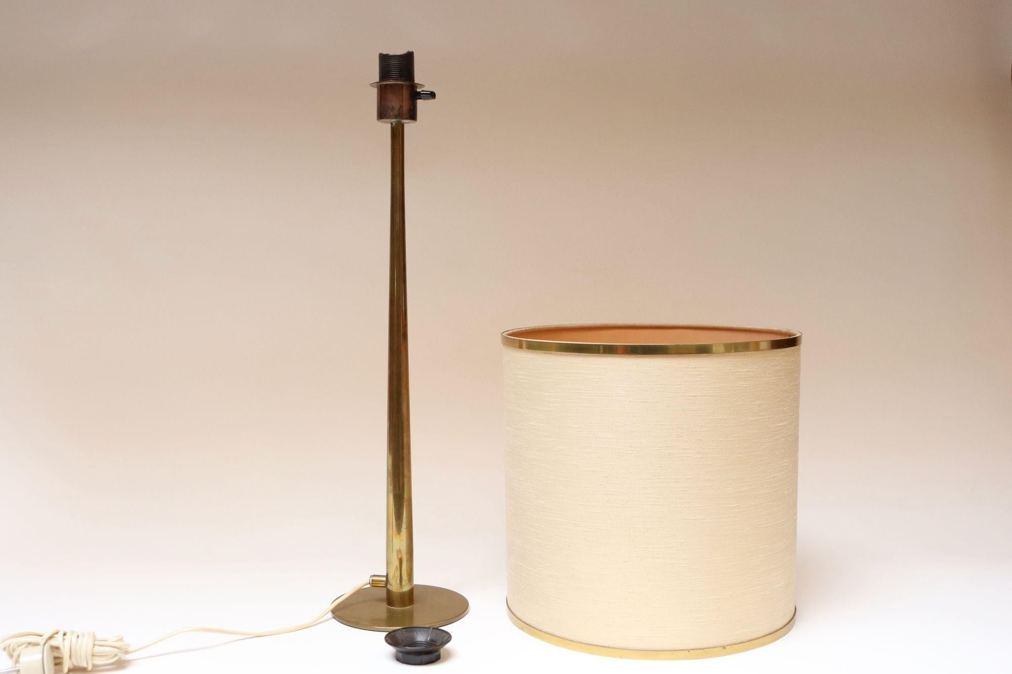 Hohe Tischleuchte Modell B66 aus massivem Messing von Hans Agne Jakobsson in (ca. 1960er Jahre, Markaryd, Schweden).
Originaler Zustand mit dem kaum sichtbaren, originalen Leinenschirm mit Messingbändern oben und unten, Bakelitschalter und