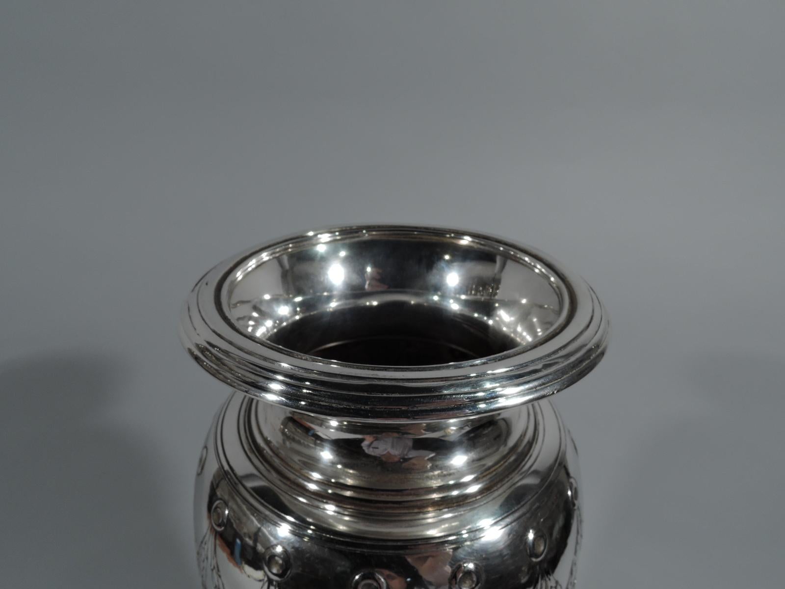 Tall Art Deco sterling silver vase. Made by Tiffany & Co. in New York, circa 1920. Ovoid with short neck and slightly turned-down rim, and stepped foot. Modern Classical ornament with chased pendant swags and scrollwork as well as reeding and