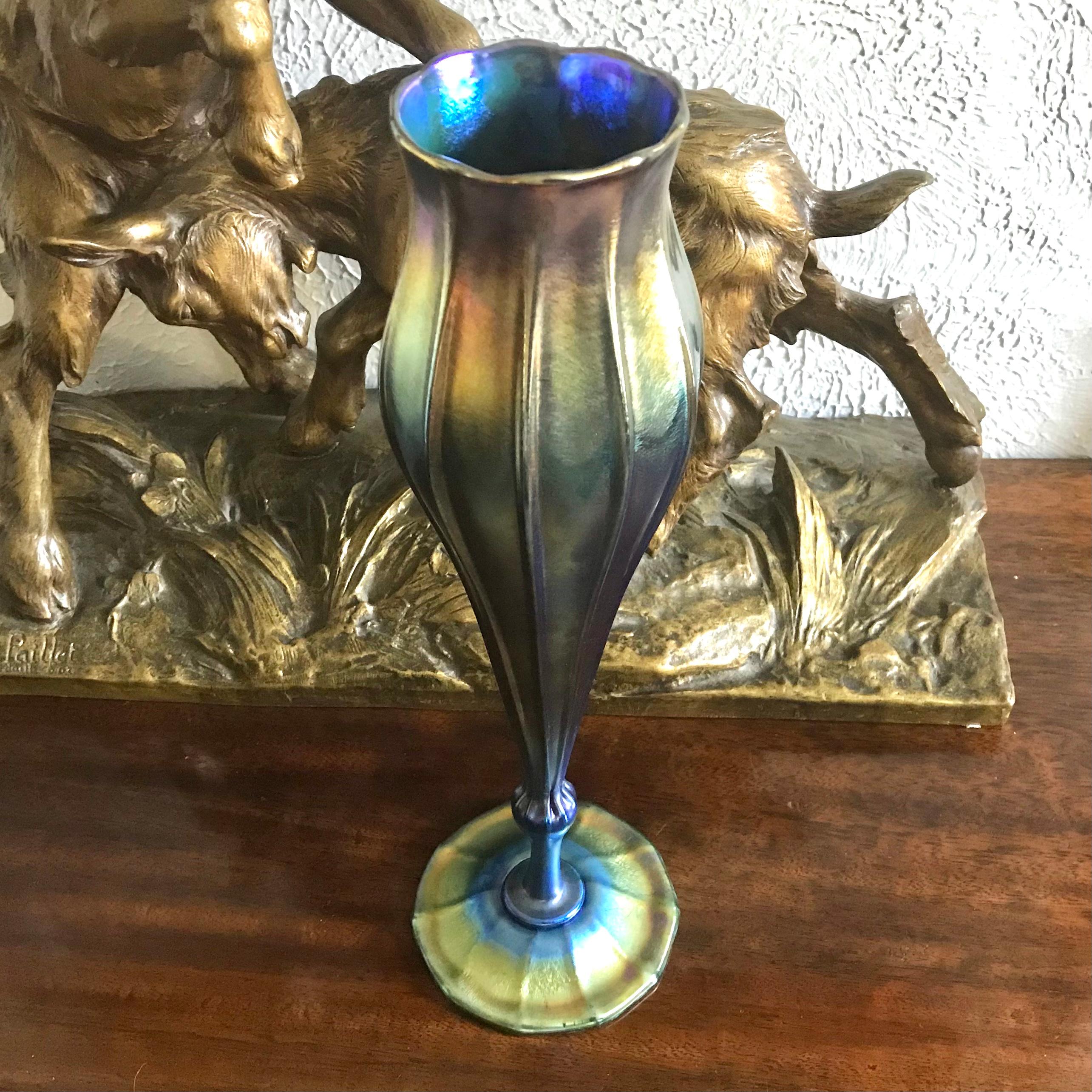 A spectacular Louis Comfort Tiffany favrile vase with a rainbow or iridescent colors ranging from blue, green, gold, purple and red. Standing tall at over 15 inches, this ribbed pedestaled floriform Tiffany case is special and magnificent. Art