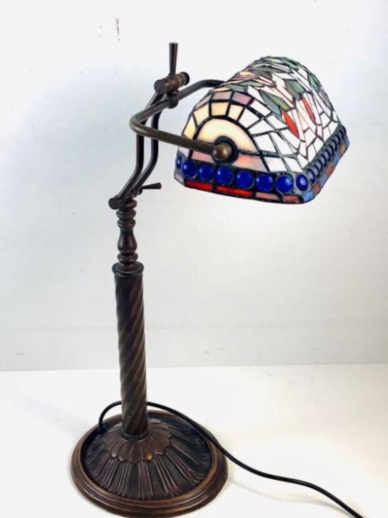 Lampe de bureau de banquier de style Tiffany, France, 1950-1959. Fabuleuse lampe de bureau ou de table ajustable avec un magnifique abat-jour en verre peint à la main selon la technique Tiffany de verres au plomb multicolores sur une base en bronze