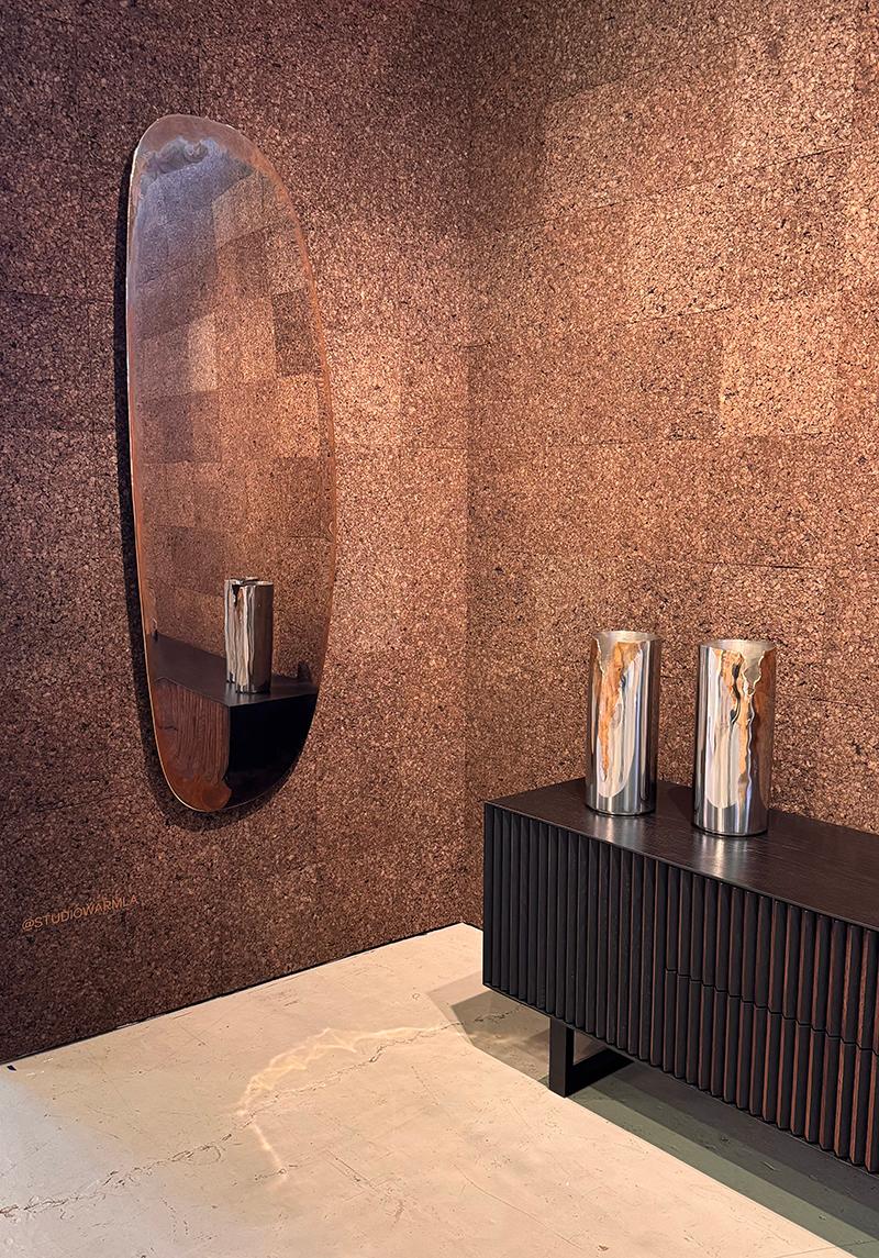 Con un'altezza di 69 pollici, questo specchio a parete in acciaio inox lucido con dettagli in bronzo che corrono lungo l'intero perimetro è un vero e proprio pezzo forte, installato in posizione sfalsata rispetto alla parete grazie a una ghiera