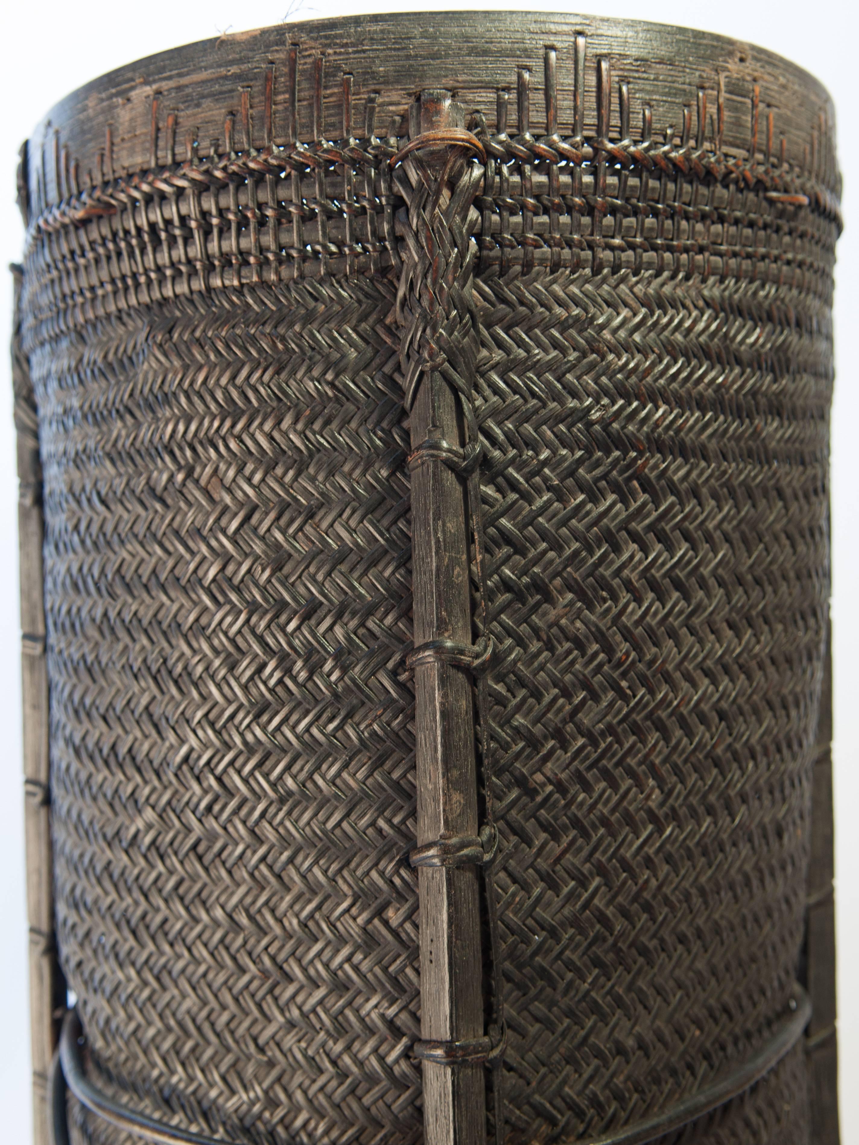 Tall tribal grain storage basket from Borneo, mid-late 20th century.
Offered by Bruce Hughes.
Rattan and bamboo basket from west Borneo. Hand fashioned from rattan and bamboo.
Condition: There is minor damage to the rattan in a couple of small