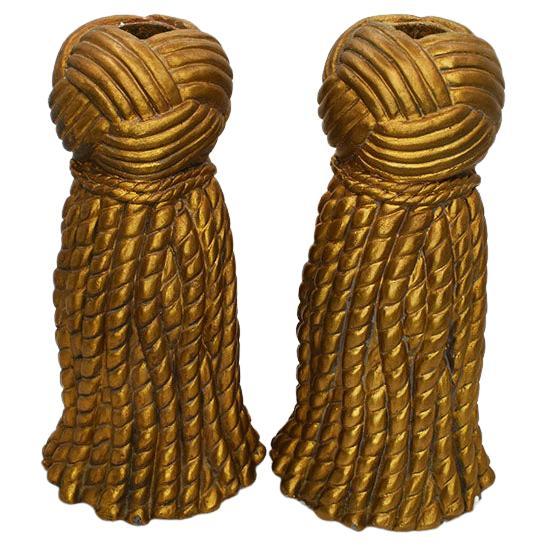 A pair of tall Grand Millennial gold tassel candlestick holders. Each gilt holder is tall, in a Trompe l'oeil tassel motif. This set will be the perfect addition to any supper table or accent your next dinner party. 

Dimensions:
7.75