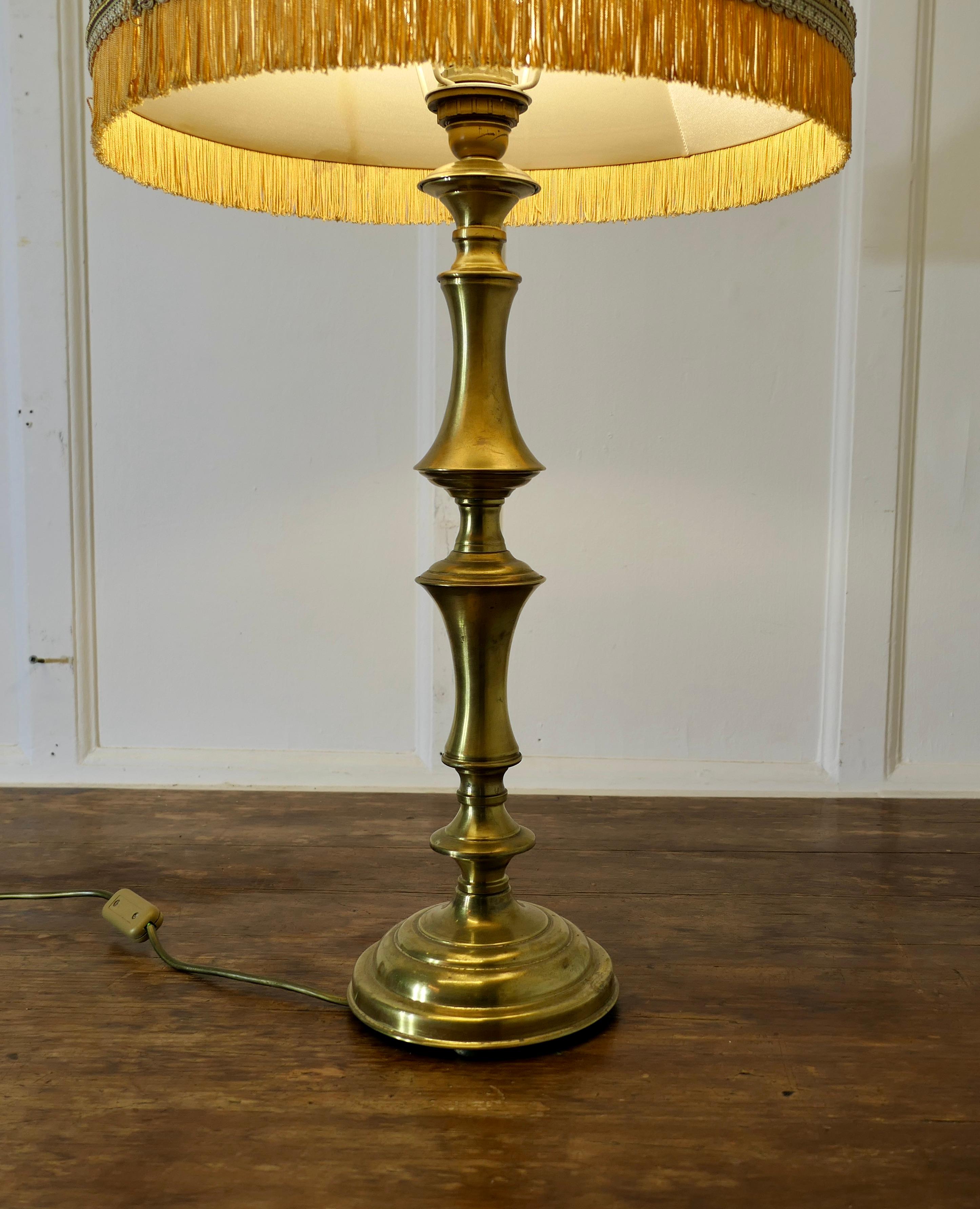 Tall Turned Column Brass Table Lamp, with Oversize Shade

This is a very attractive lamp it has an attractive shaped column and comes with its original oversize fringed linen shade
The lamp is in good condition, working and with a bright patina, the