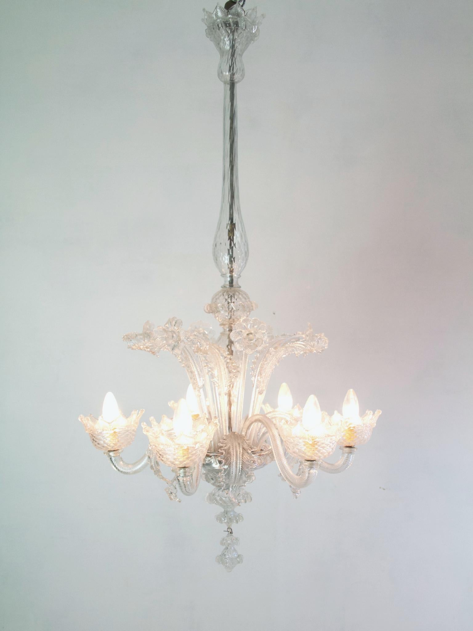 This is a very nice and a bit unusual example of a classical chandelier from Murano in the Venetian style in clear glass with six arms for lights. It is a bit unusual because it can be hung two different ways, either short at 80 cm or tall at 125