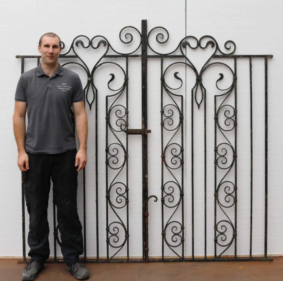 This set of tall reclaimed garden gates make a beautiful feature as pedestrian gates, bringing style to a garden or yard with their ornate design as well as security with their tight vertical bars. Handcrafted more than a century ago, these wrought