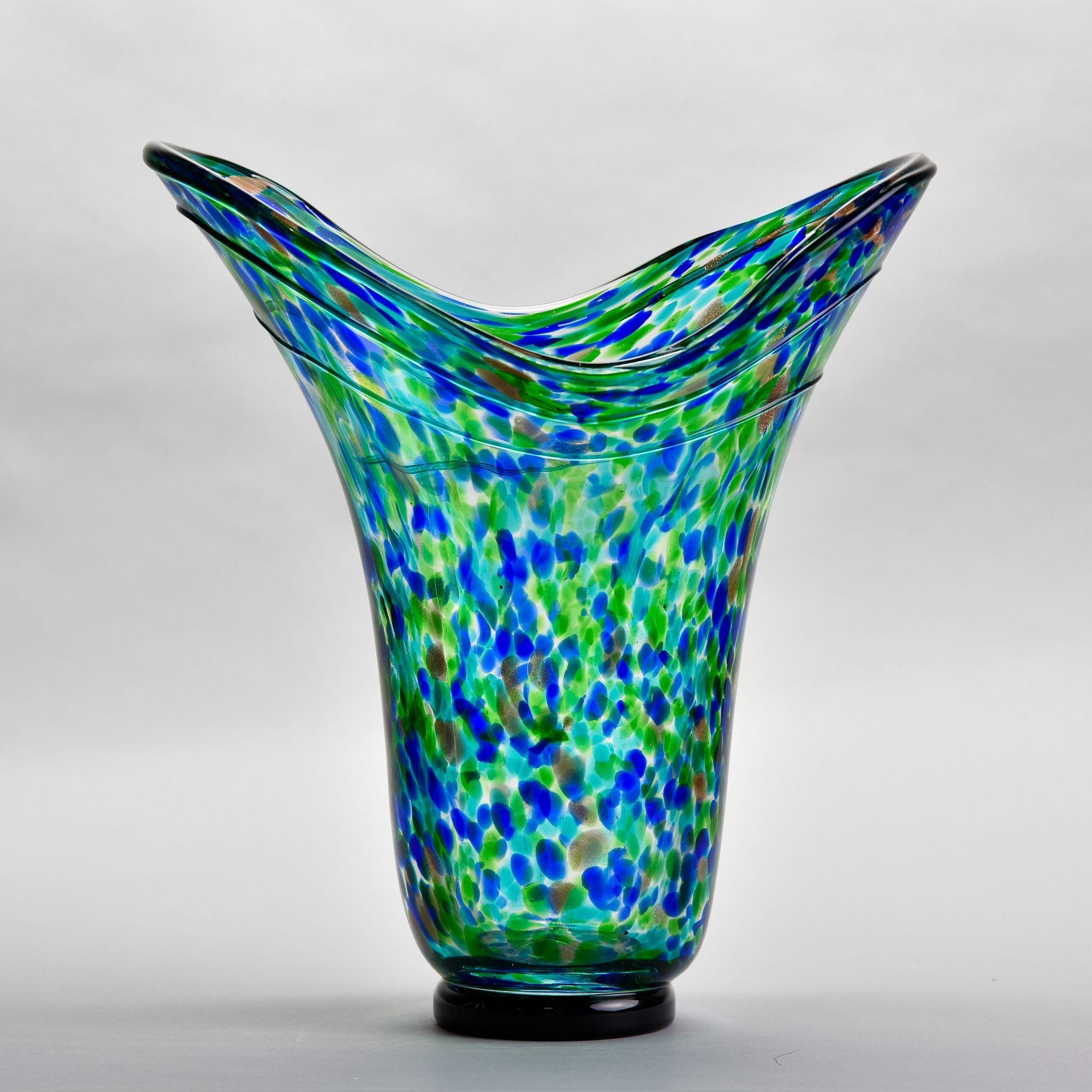 Found in the US, this circa 1990 tall art glass vase has a wide, flared neck and blue green splatter pattern with accents of metallic gold. No flaws found. Polished pontil. Unknown maker.